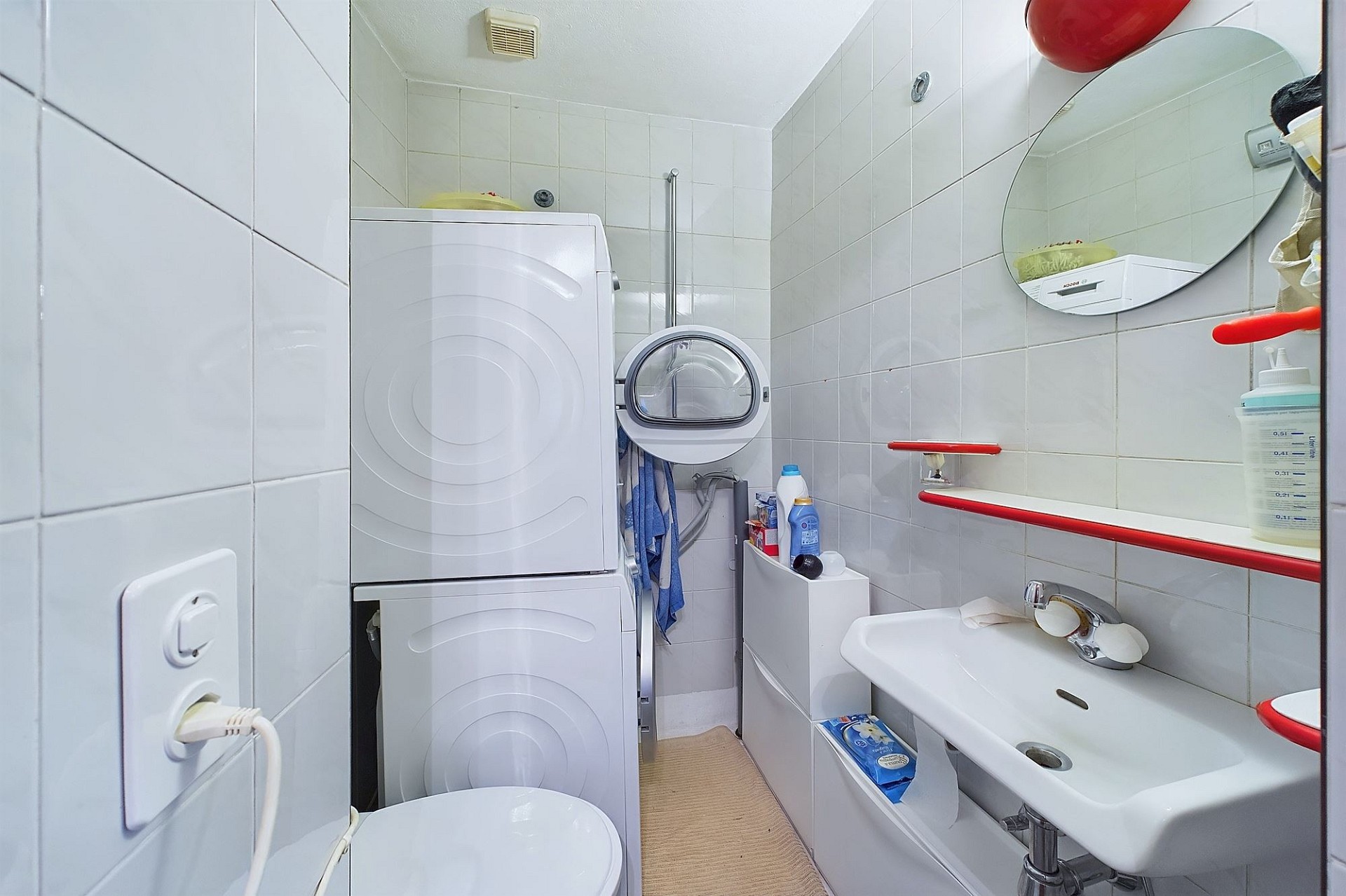 Kleines helles Badezimmer mit Waschmaschine und Waschbecken
