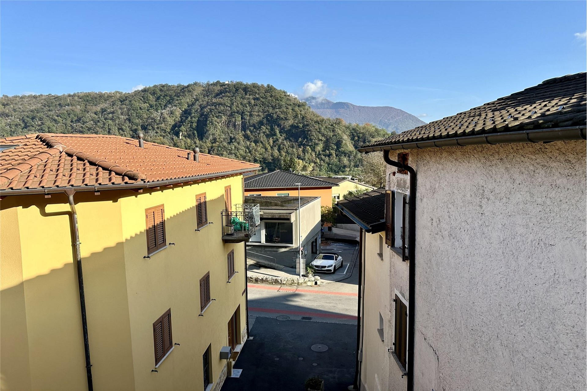 Blick zwischen Wohnhäusern auf Berglandschaft