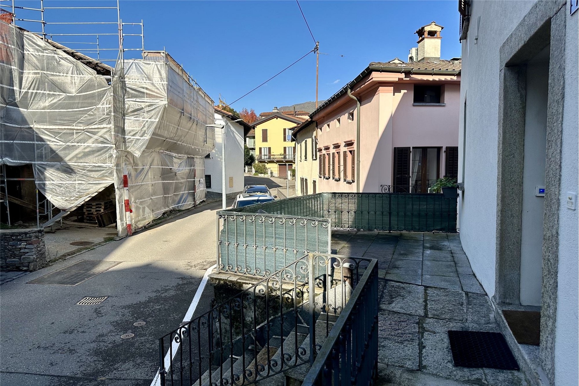Straßenblick auf Wohnhäuser mit Terrasse und Baugerüst