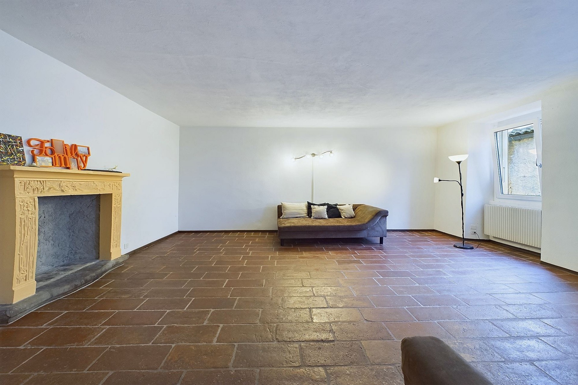 Wohnzimmer mit Kamin und Fliesenboden
