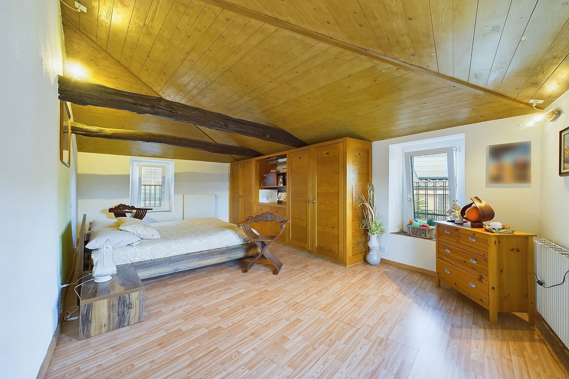 Dachgeschoss-Schlafzimmer mit rustikalem Holzcharakter