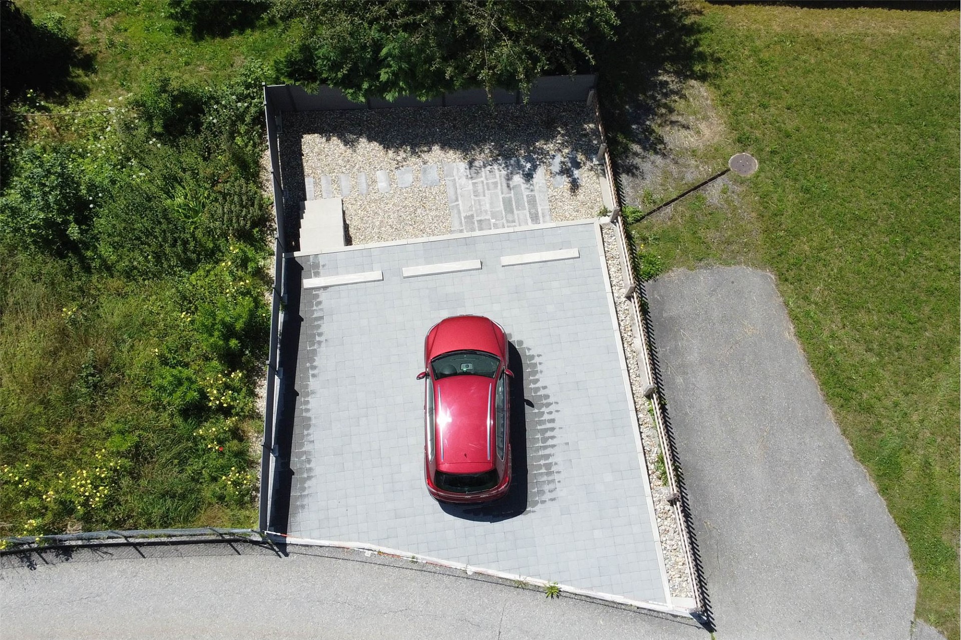 Drohnenaufnahme eines Stellplatzes mit rotem Auto