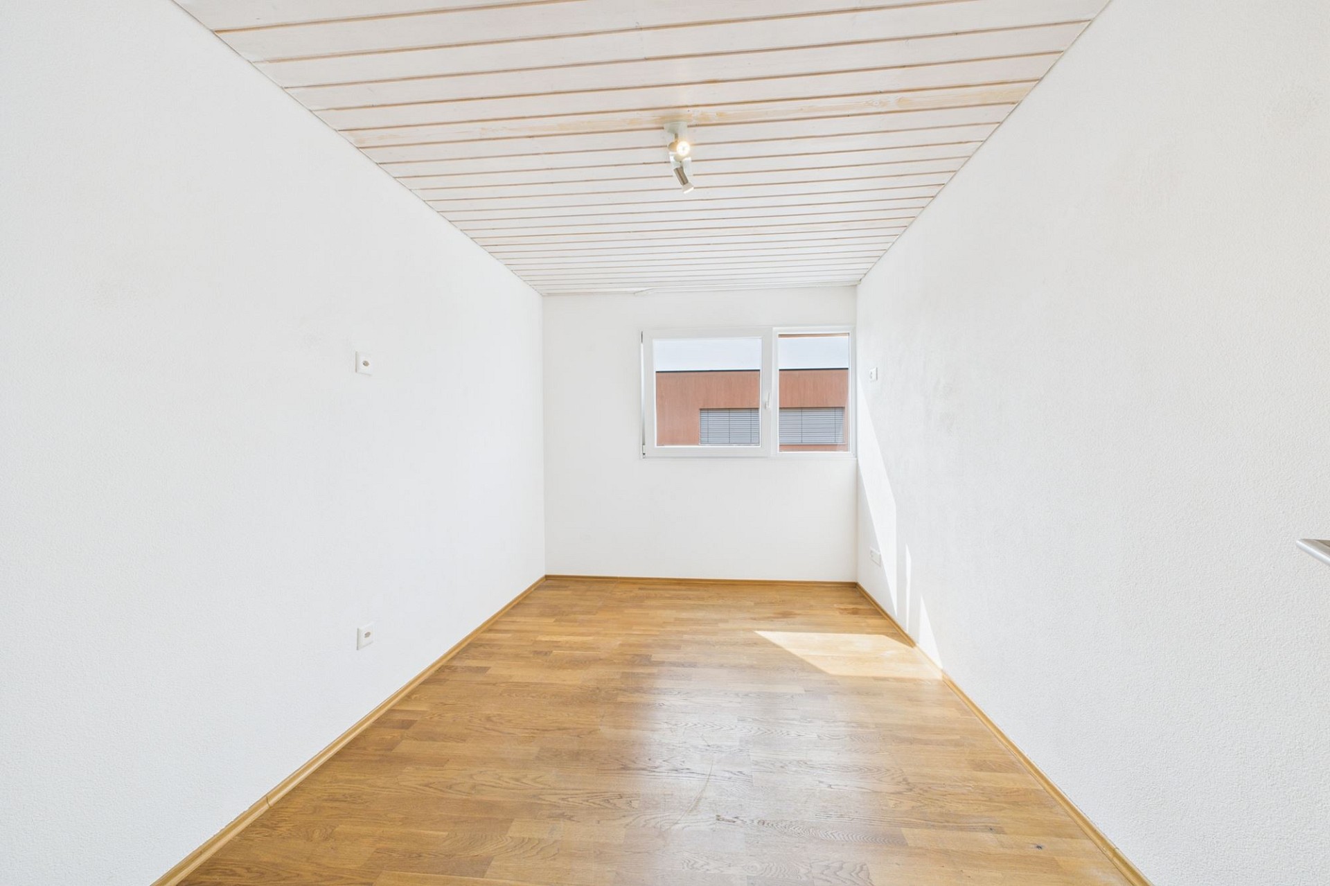 Helles, leeres Zimmer mit Holzfußboden