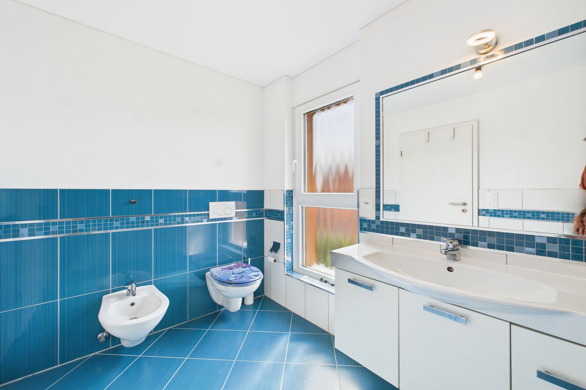 Helles Badezimmer mit blau-weißen Fliesen