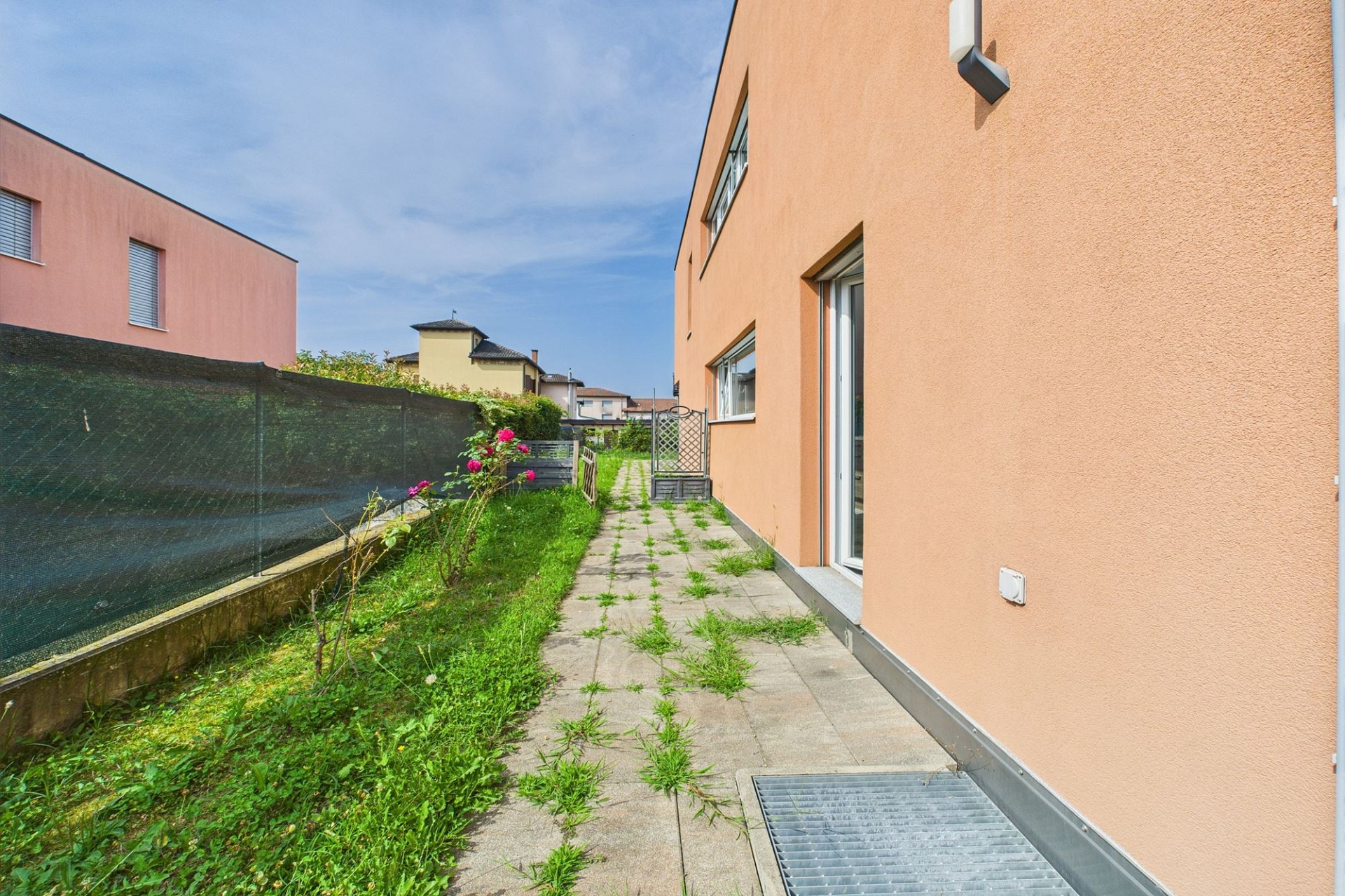 Seitlicher Außenbereich mit schmalem Gartenweg