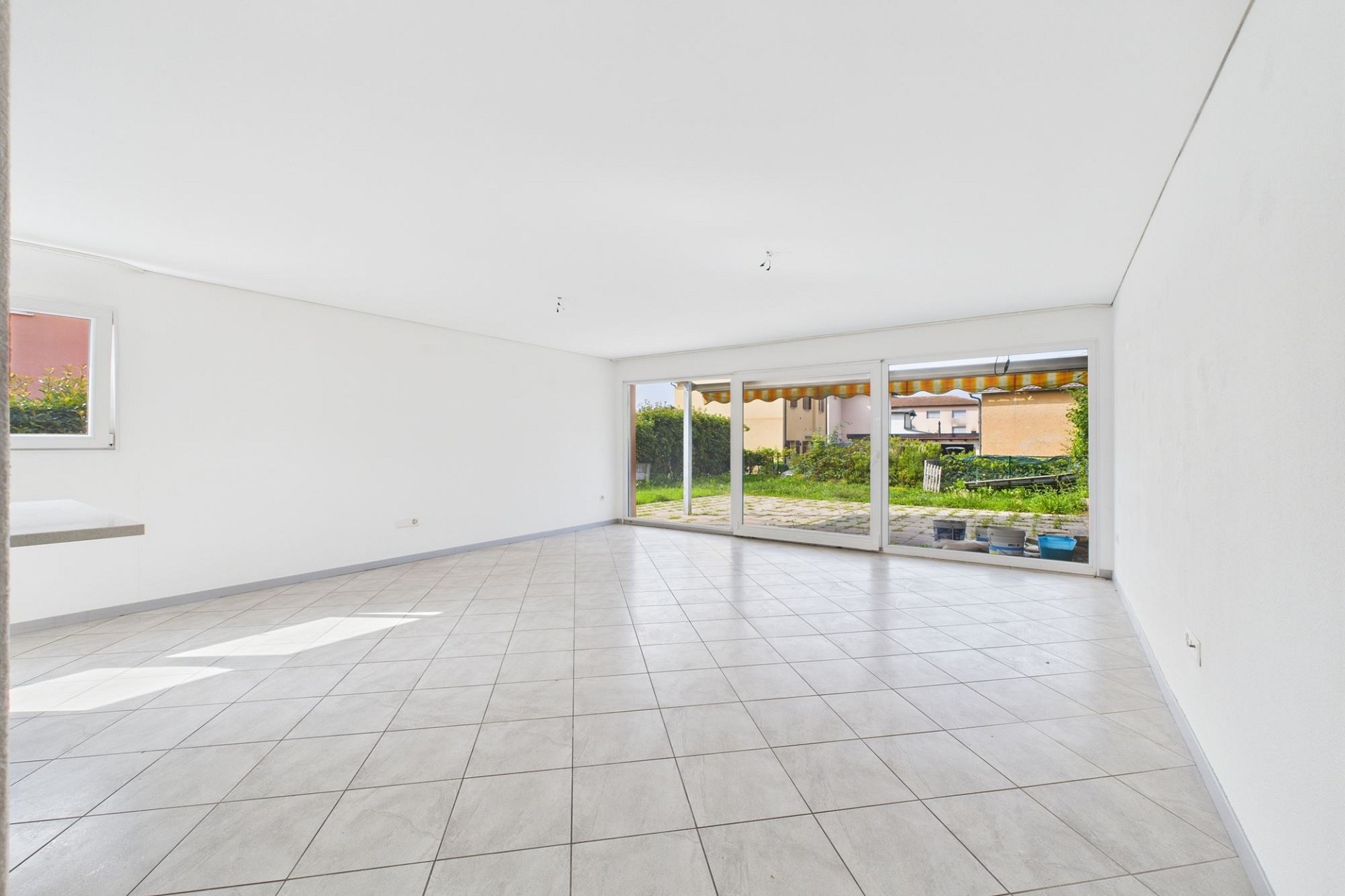 Heller, leerer Wohnraum mit Terrassenzugang