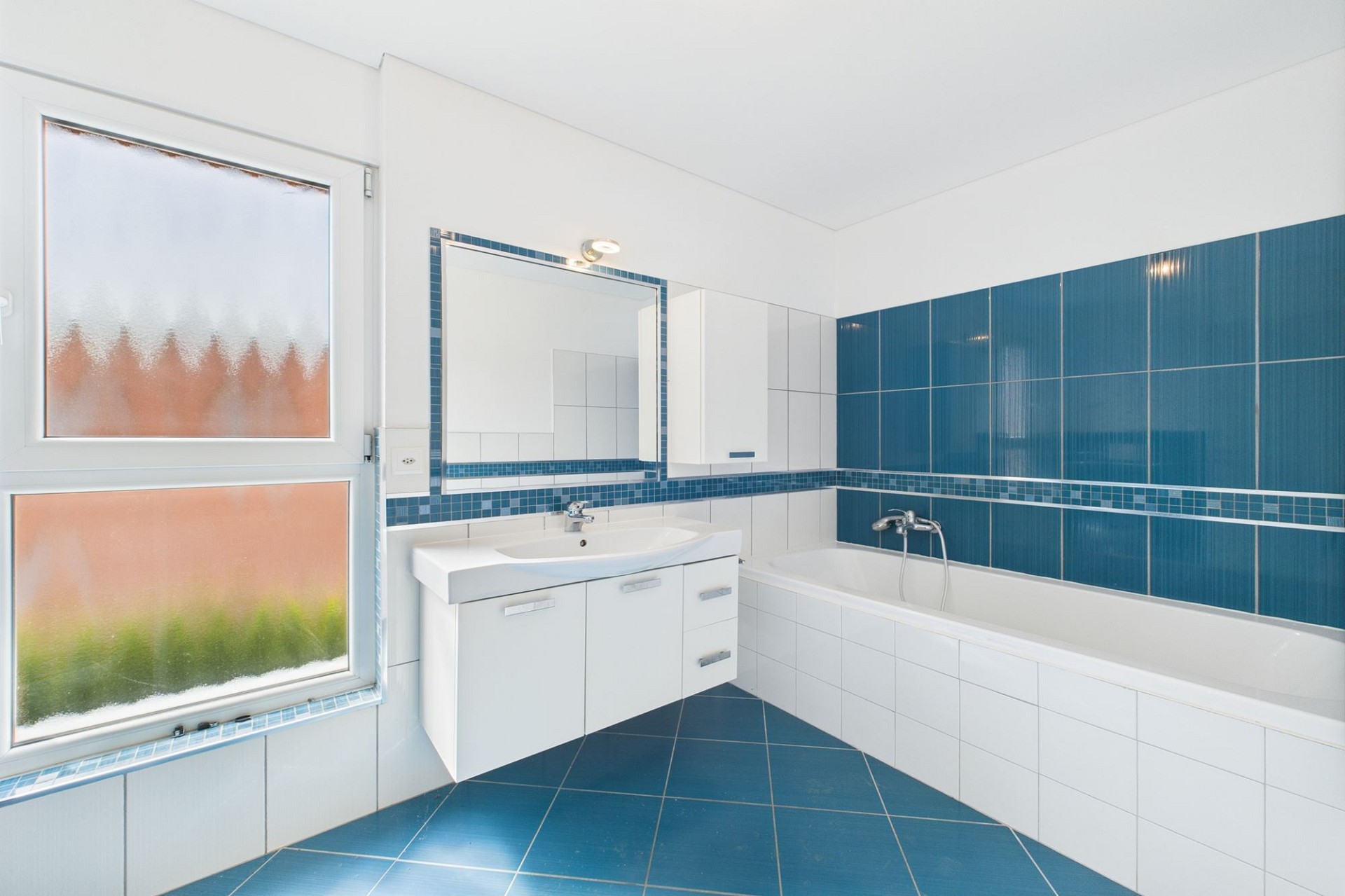 Modernes Badezimmer mit blau-weißer Fliesenoptik