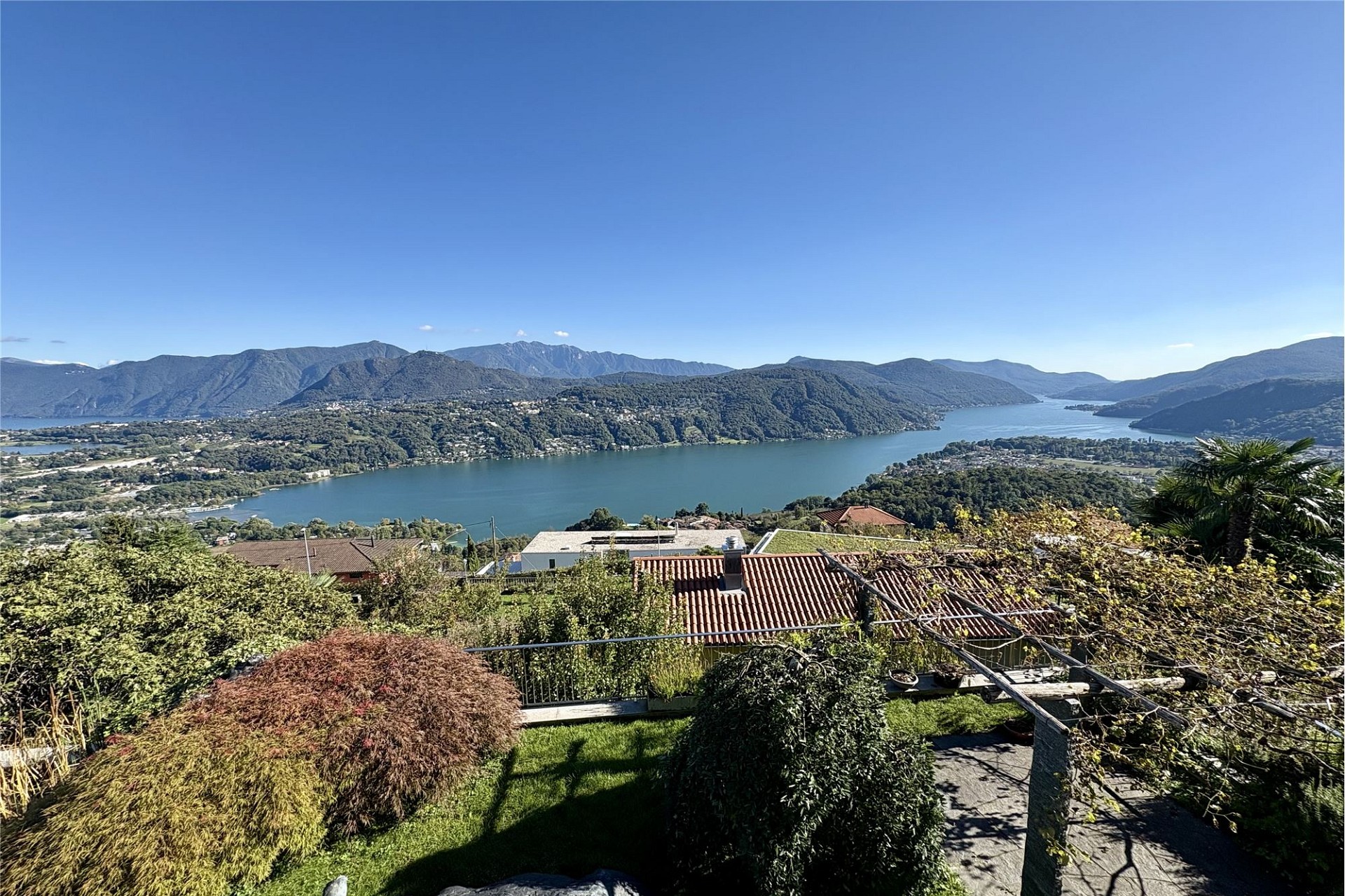 Seeblick mit Bergen und Garten
