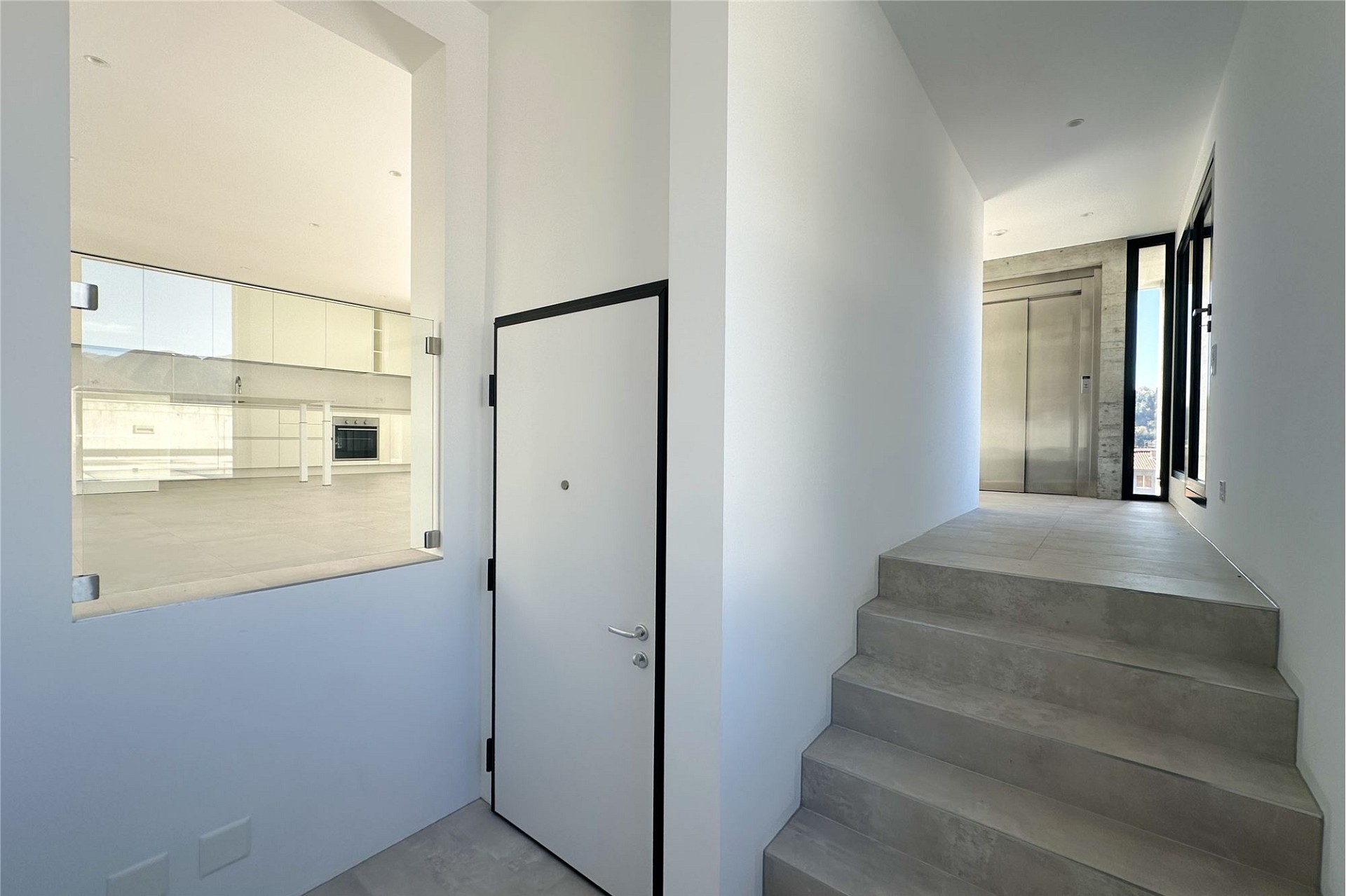 Moderner Eingangsbereich mit Treppe und Blick zur Küche