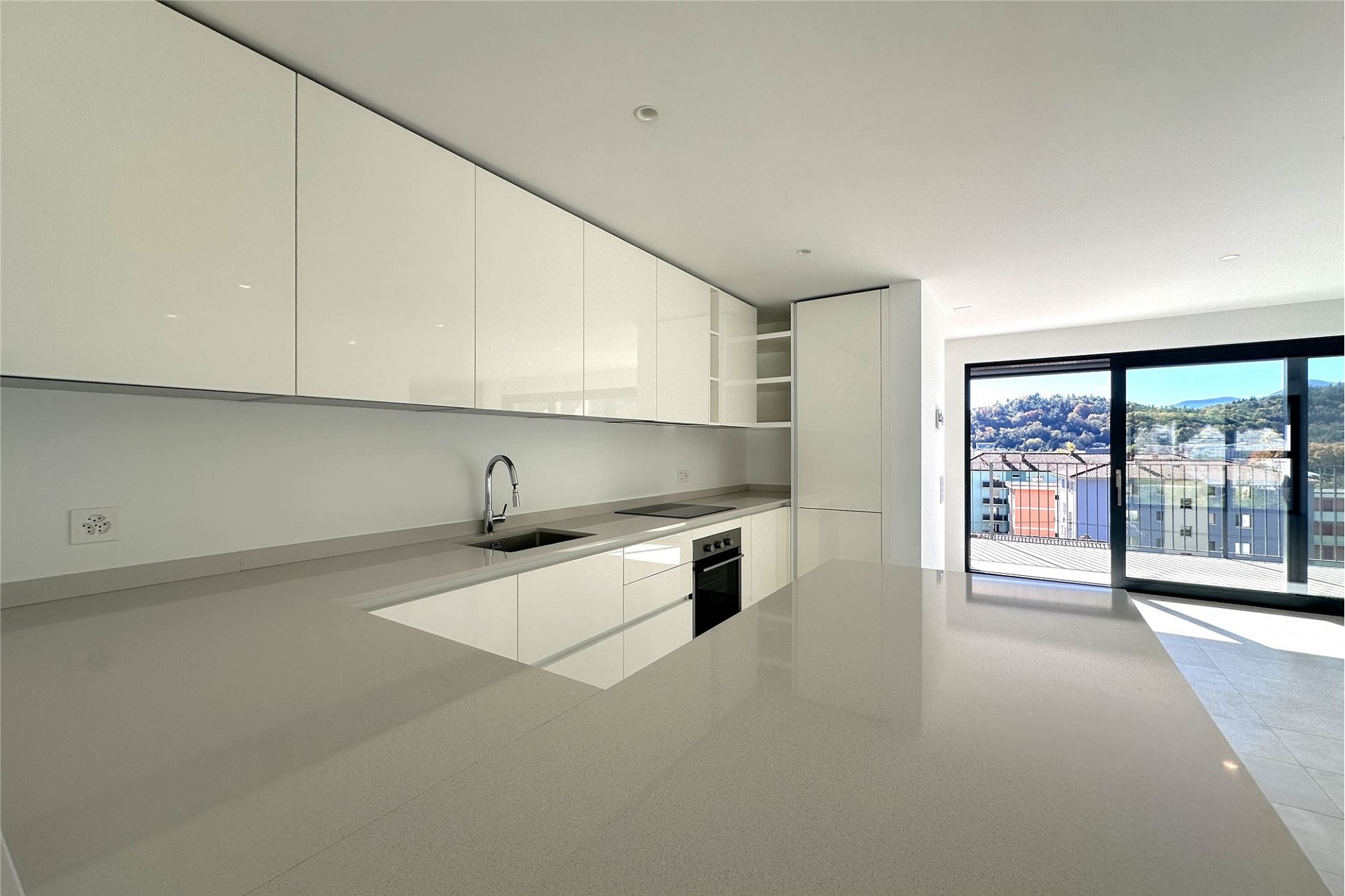 Moderne, helle Küche mit Balkonblick