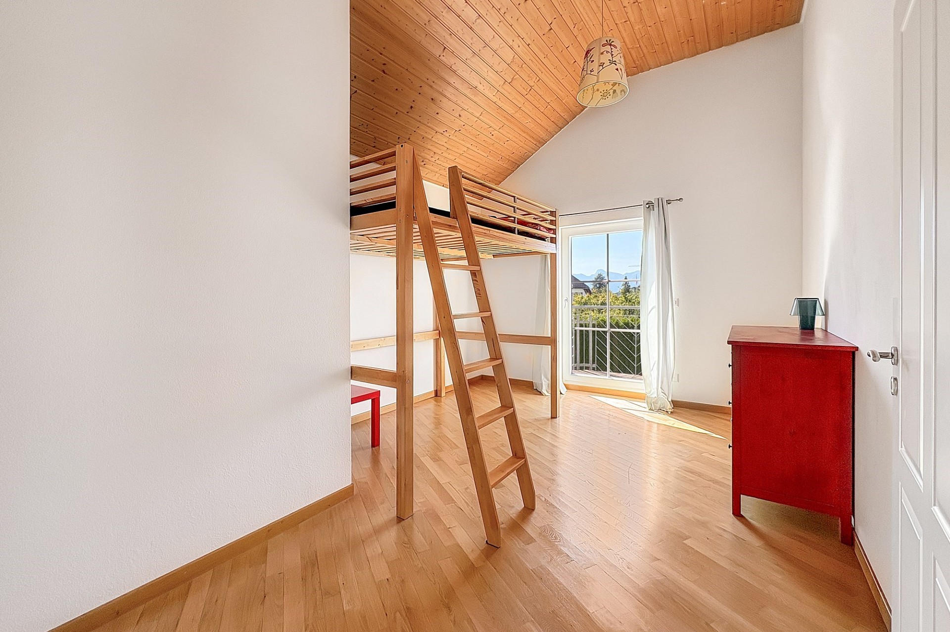 Hell eingerichtetes Dachzimmer mit Hochbett