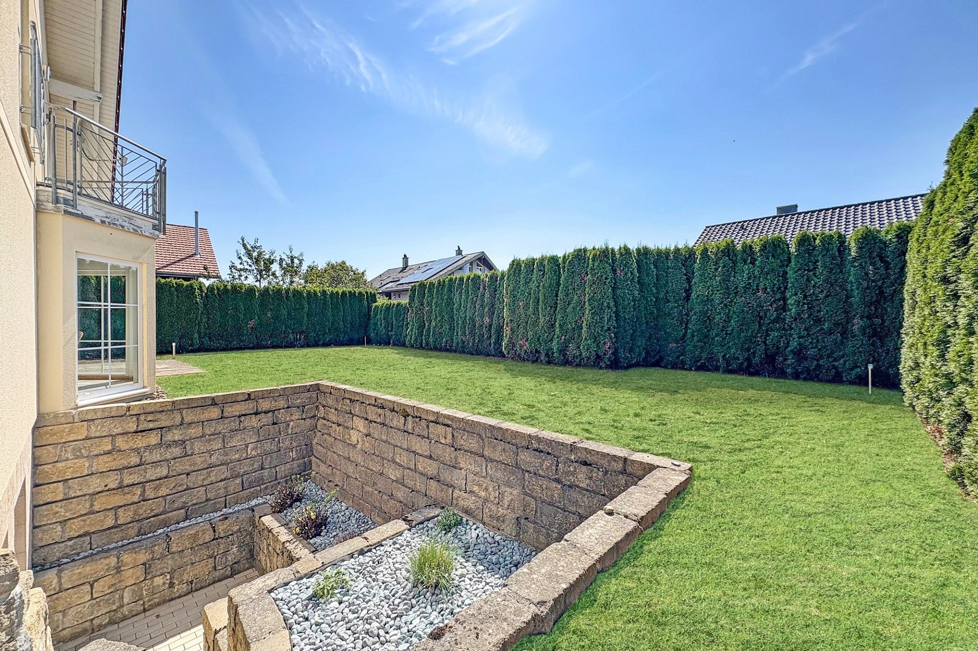 Gepflegter Garten mit Terrasse und Nachbarbebauung