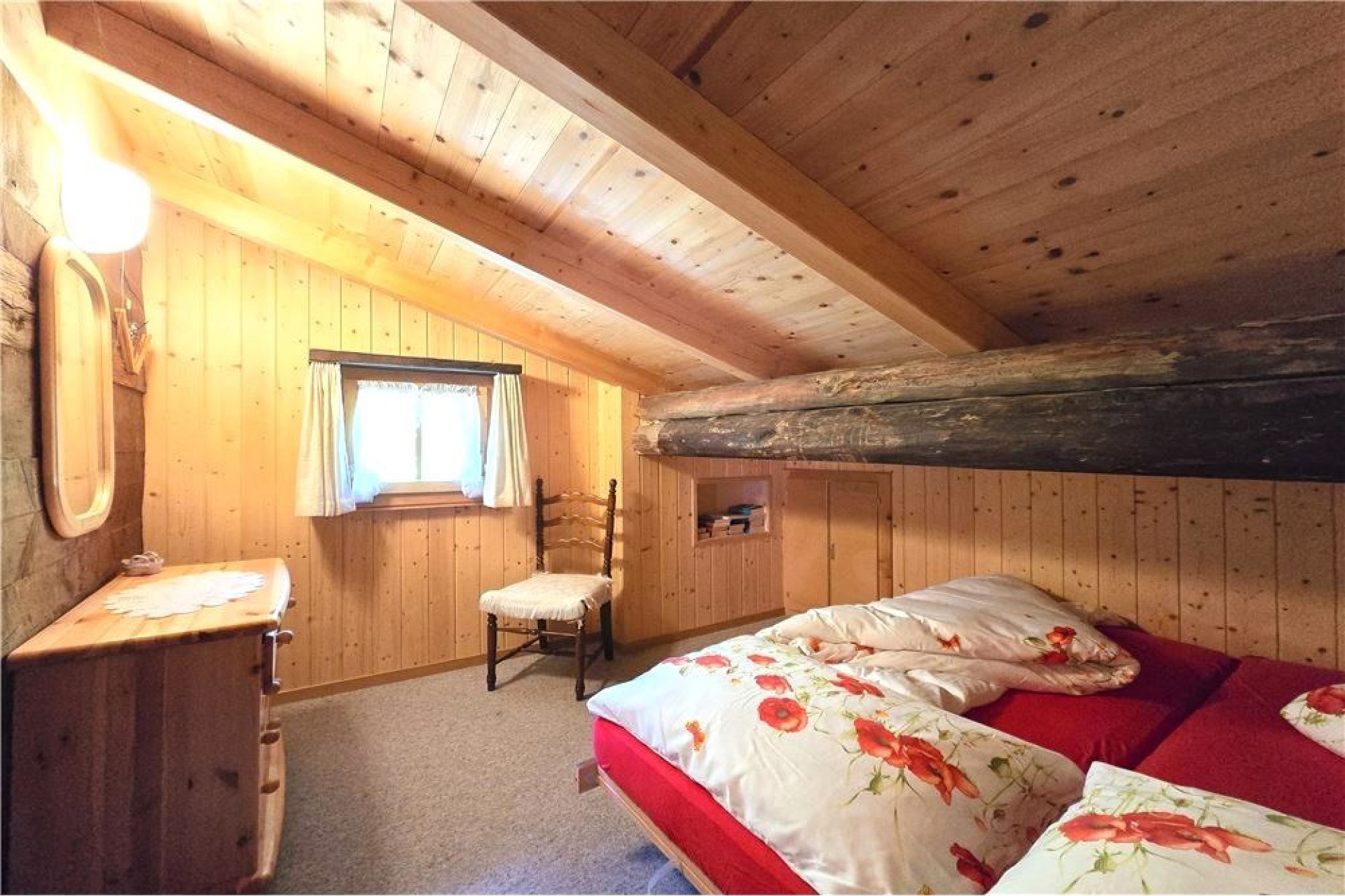 Rustikales Schlafzimmer mit Holzvertäfelung und Schrägdach