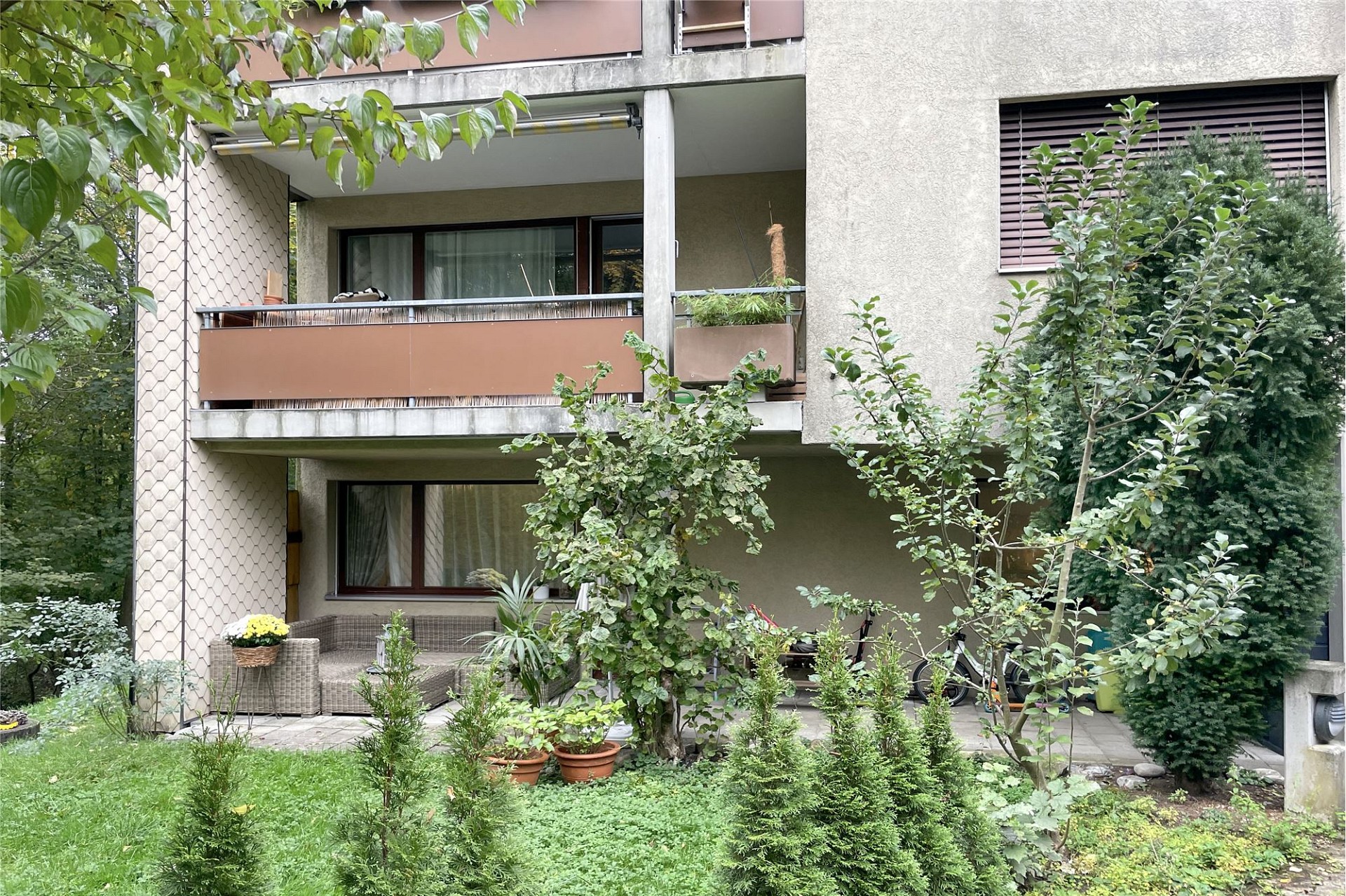 Wohnhaus mit begrüntem Vorgarten und Balkon