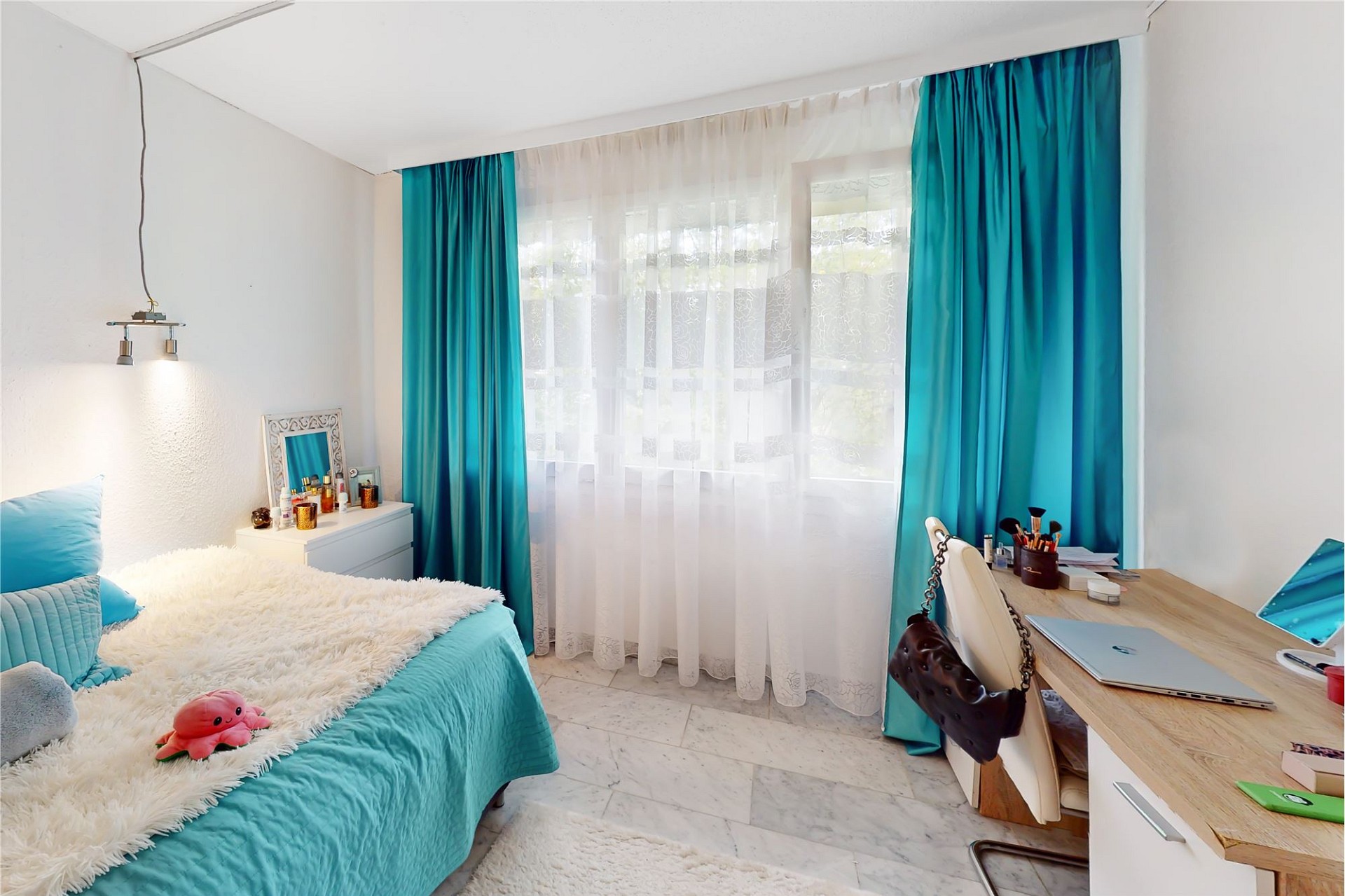 Helles Schlafzimmer mit Schreibtisch am Fenster
