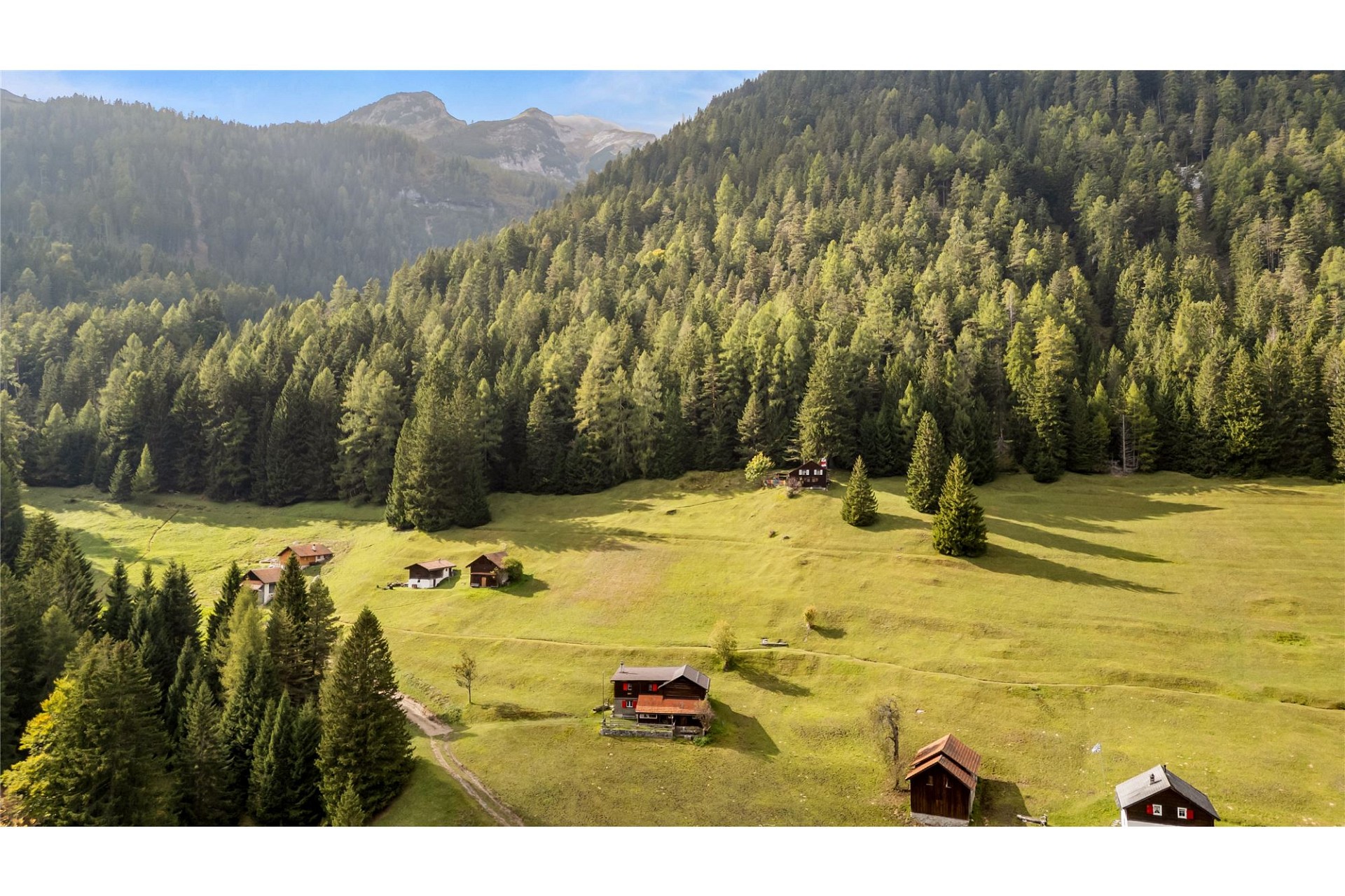 Alpines Tal mit verstreuten Hütten