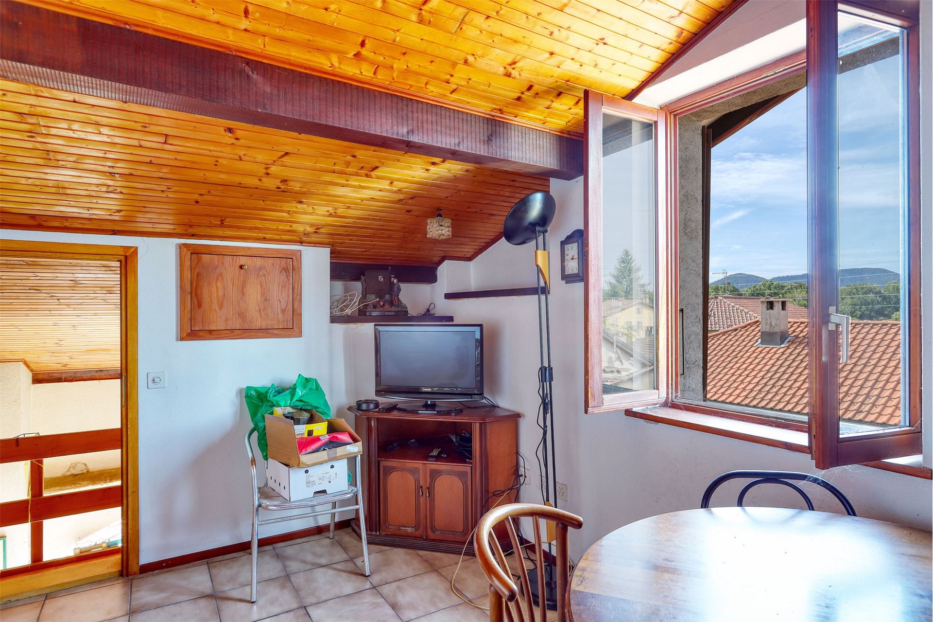 Dachgeschossraum mit Holzdecke und Blick ins Freie
