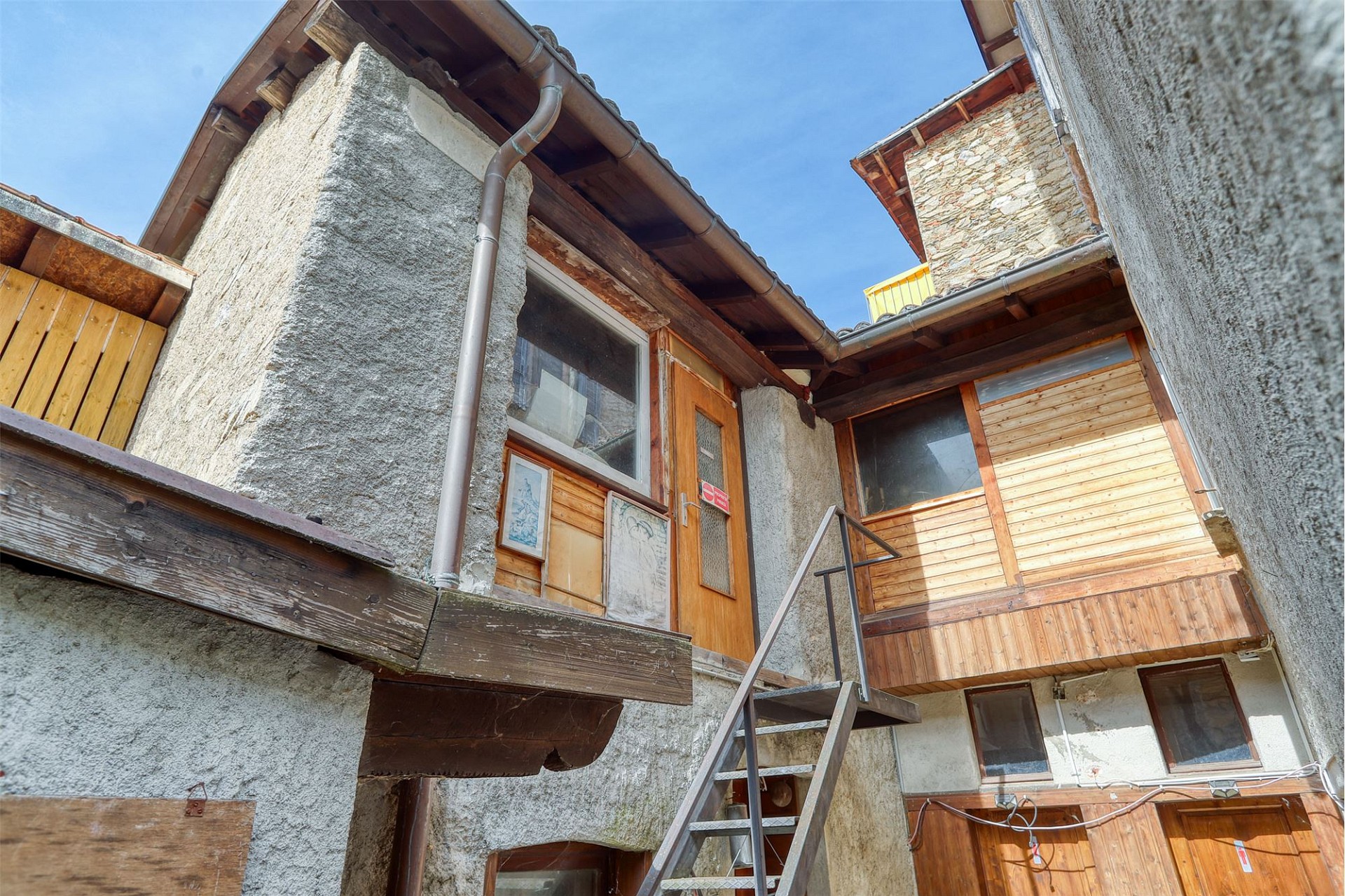 Innenhof mit rustikalen Fassaden und Holzdetails