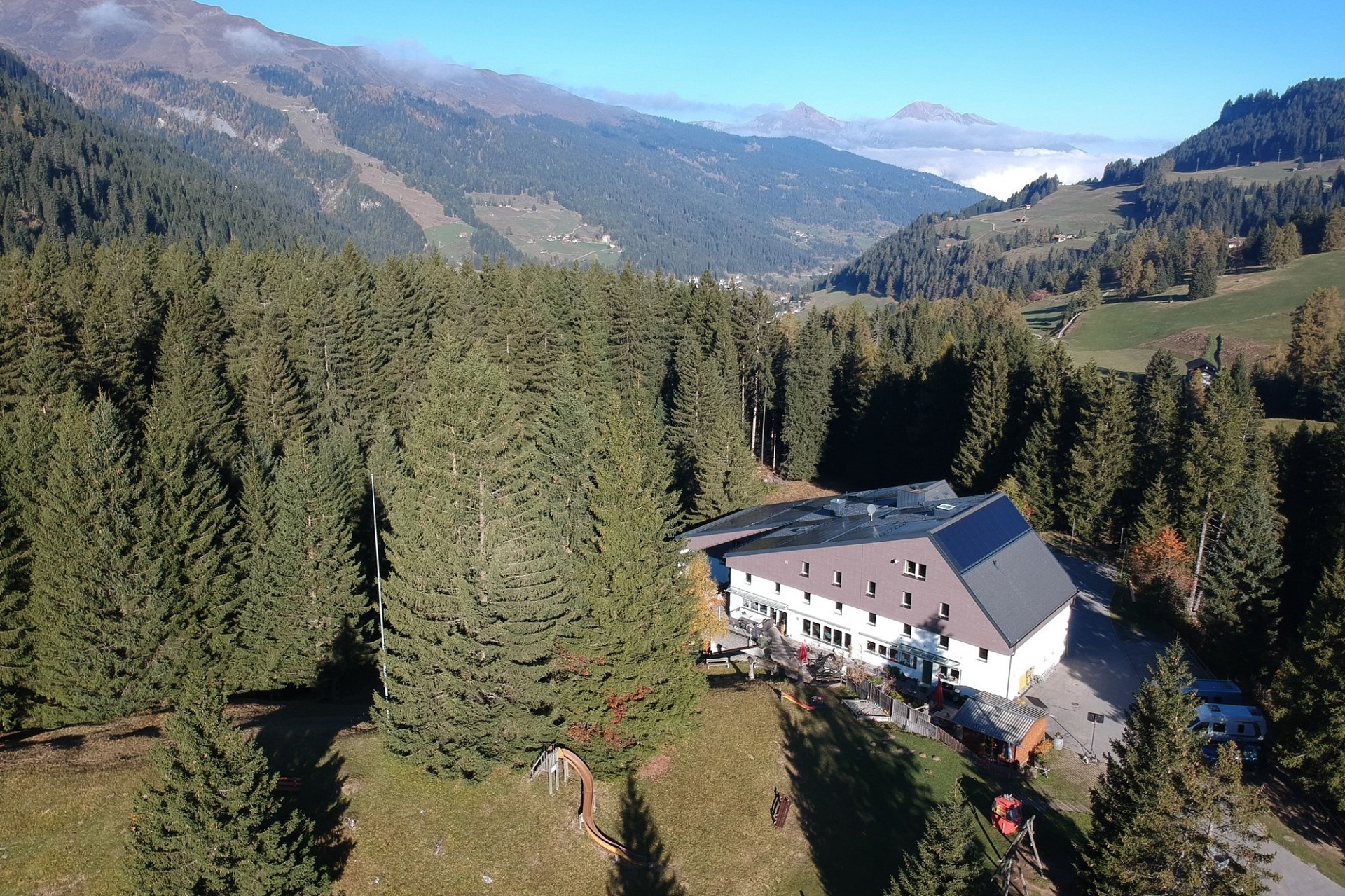 Luftaufnahme eines Berghotels in alpiner Landschaft