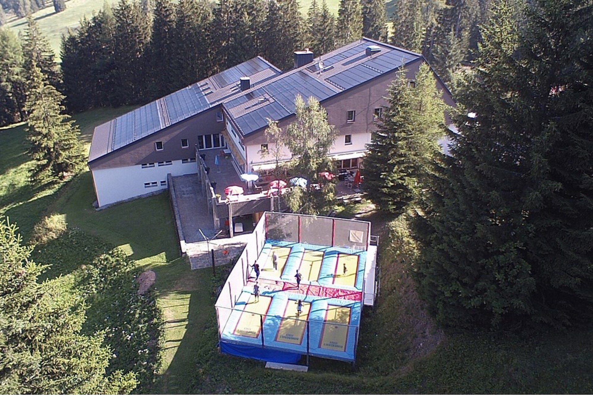 Luftaufnahme eines Hauses mit Sportbereich im Garten
