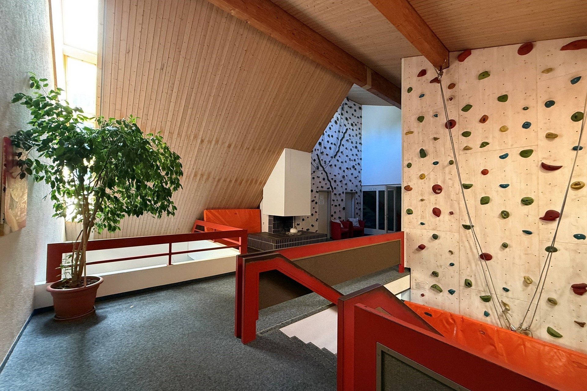 Atrium mit Kletterwand und Dachschräge