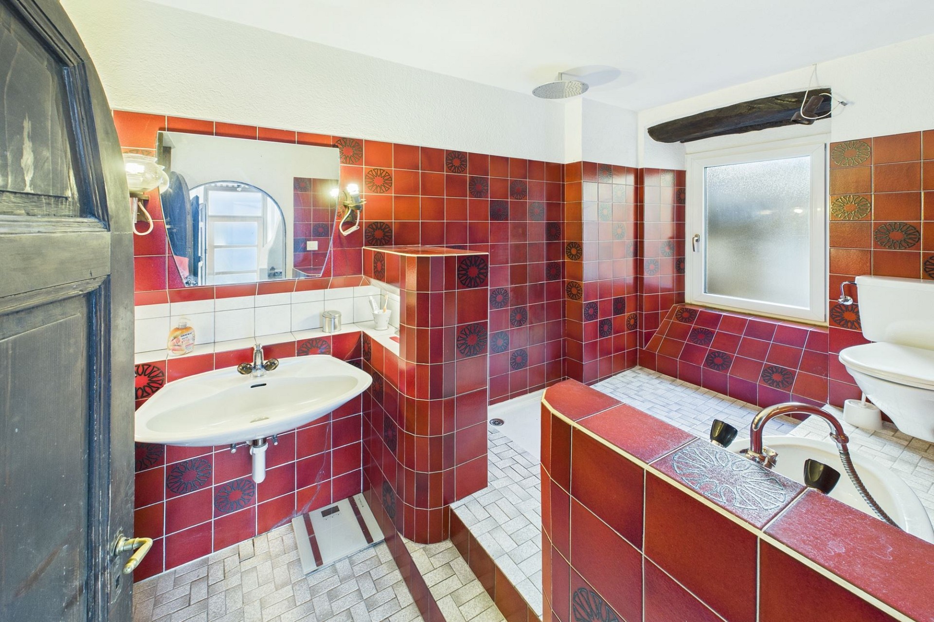 Farbig gefliestes Badezimmer mit Dusche und Wanne