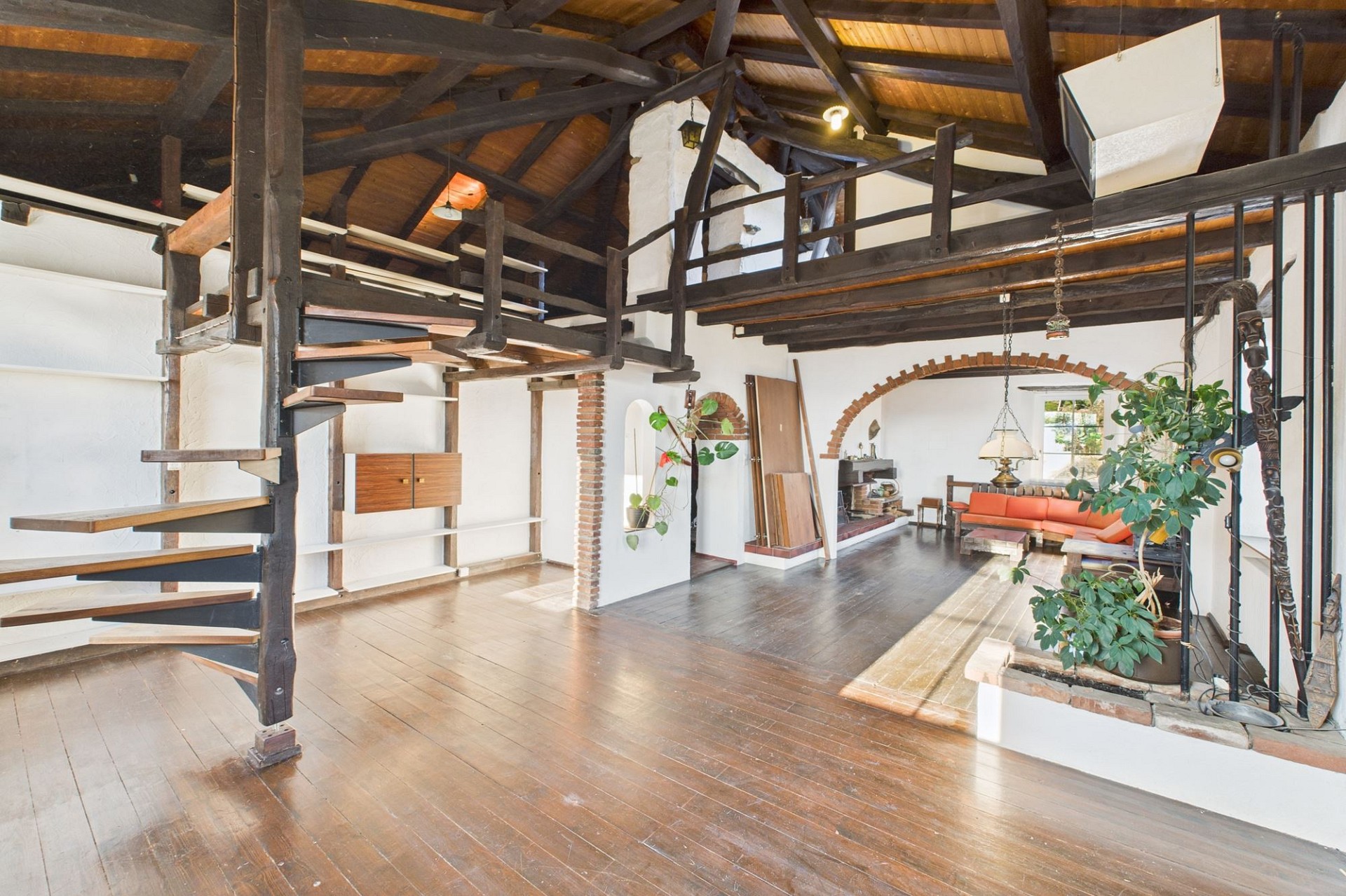 Großer offener Wohnraum mit Galerie und Holztreppe