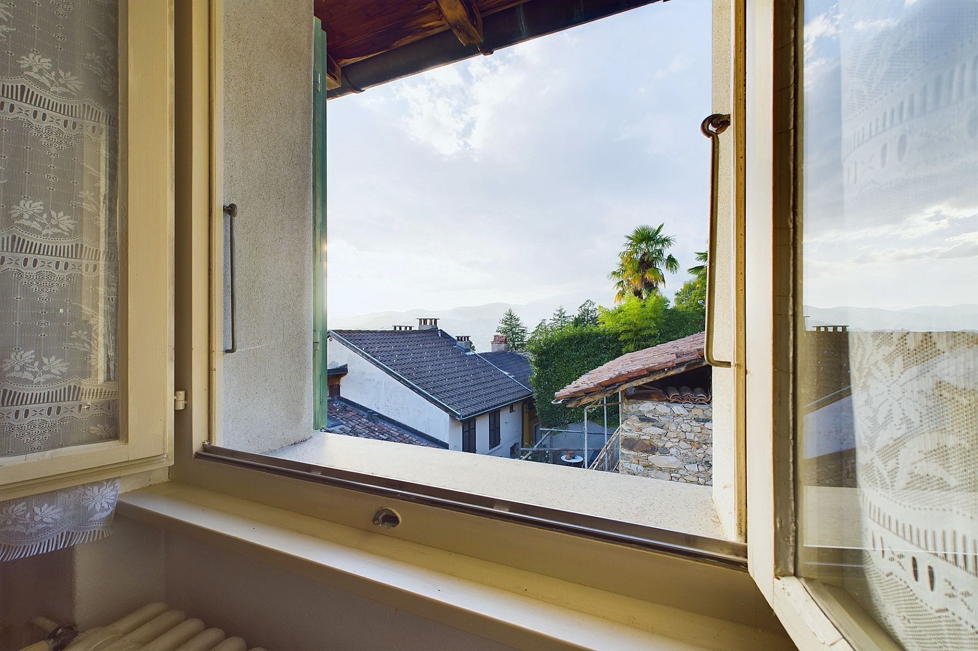 Fensterblick mit Blick auf Dächer und Berge