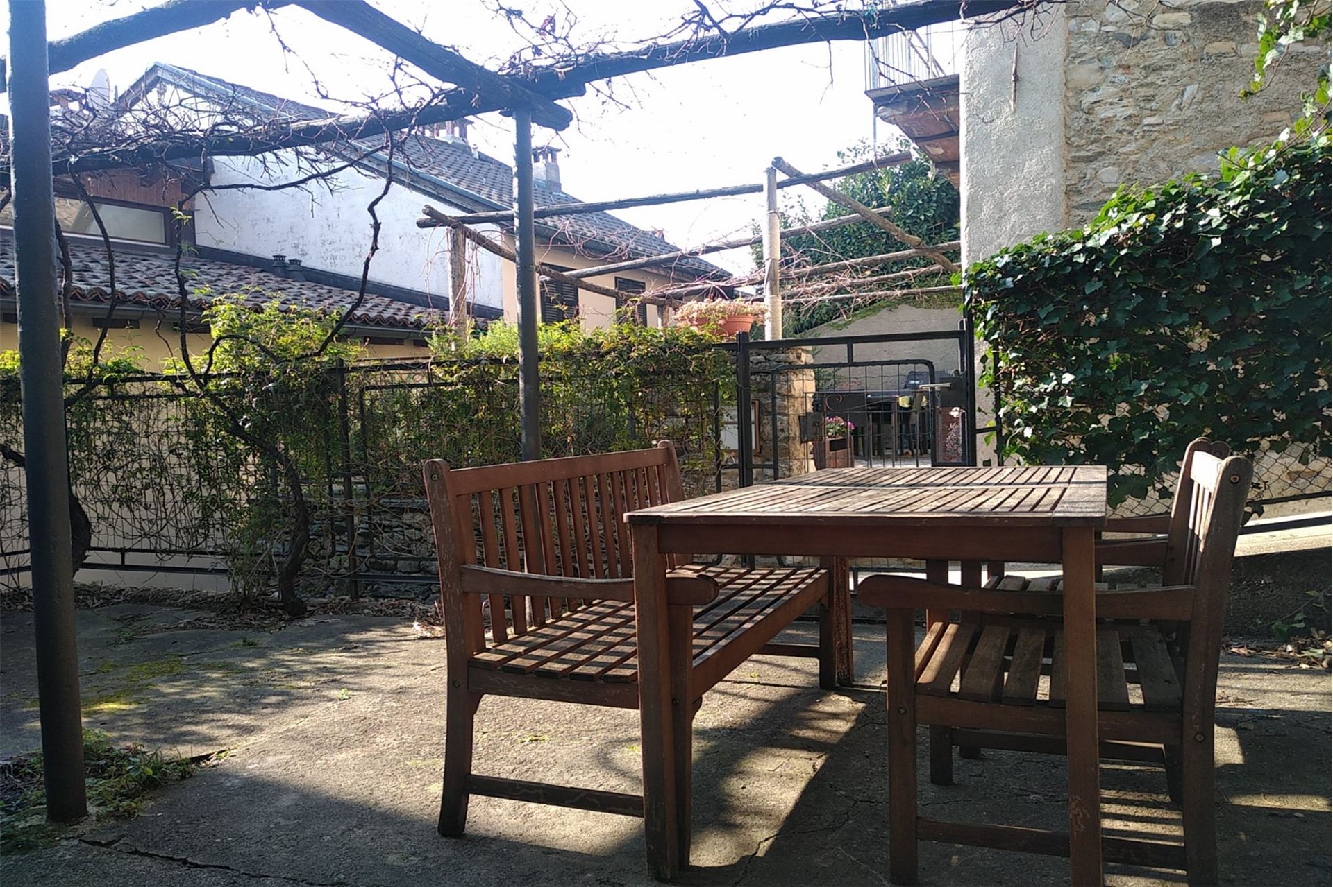 Terrasse mit Holzmöbeln und Innenhofblick