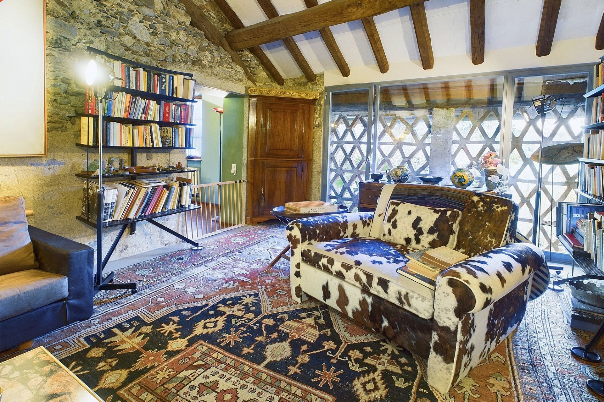 Rustikales Wohnzimmer mit sichtbaren Holzbalken und Steinwand