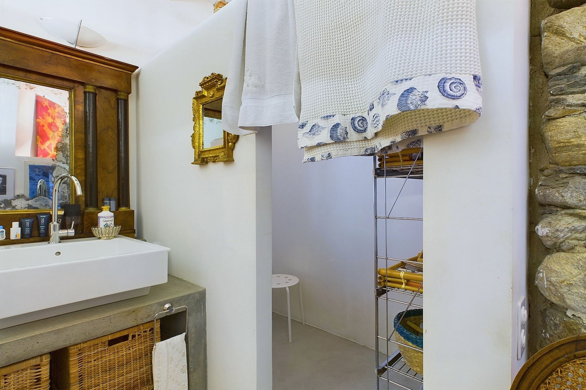 Badezimmer mit Natursteinwand und hellem Waschtisch