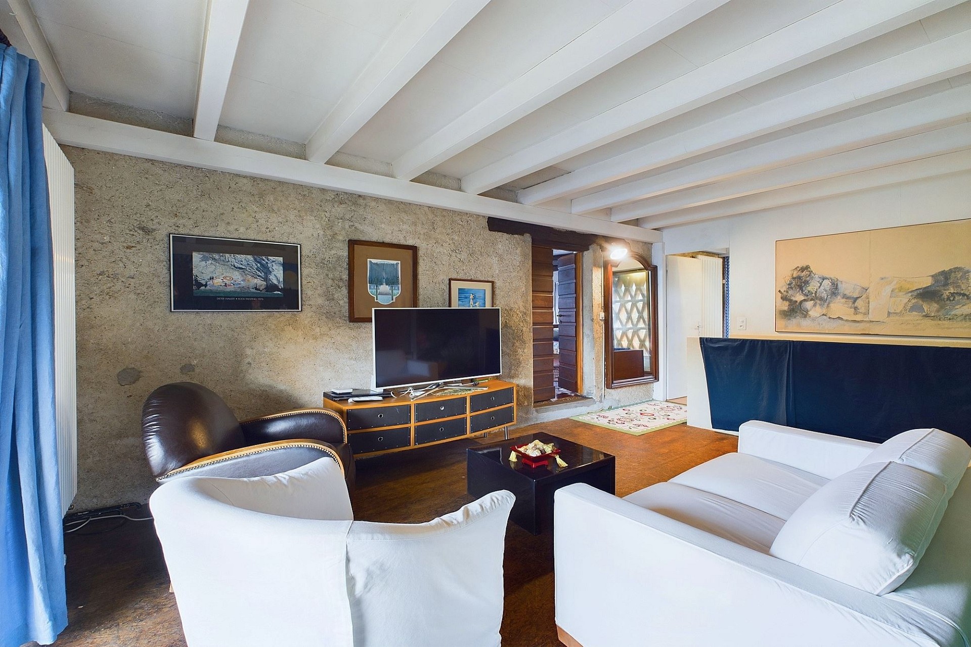 Wohnzimmer mit sichtbarer Strukturwand und Holzbalkendecke