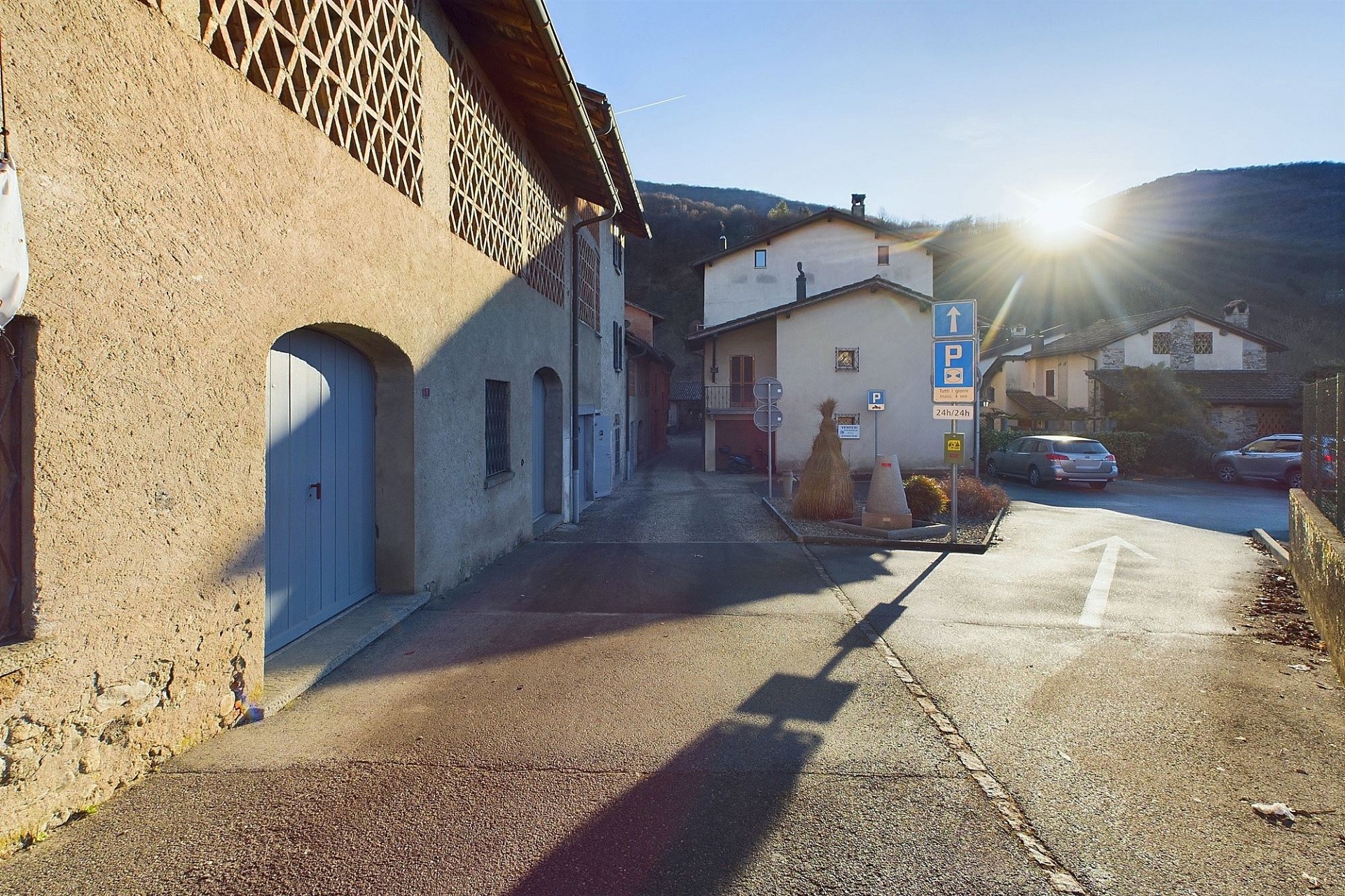 Dorfstraße mit Gebäuden und starker Sonneneinstrahlung