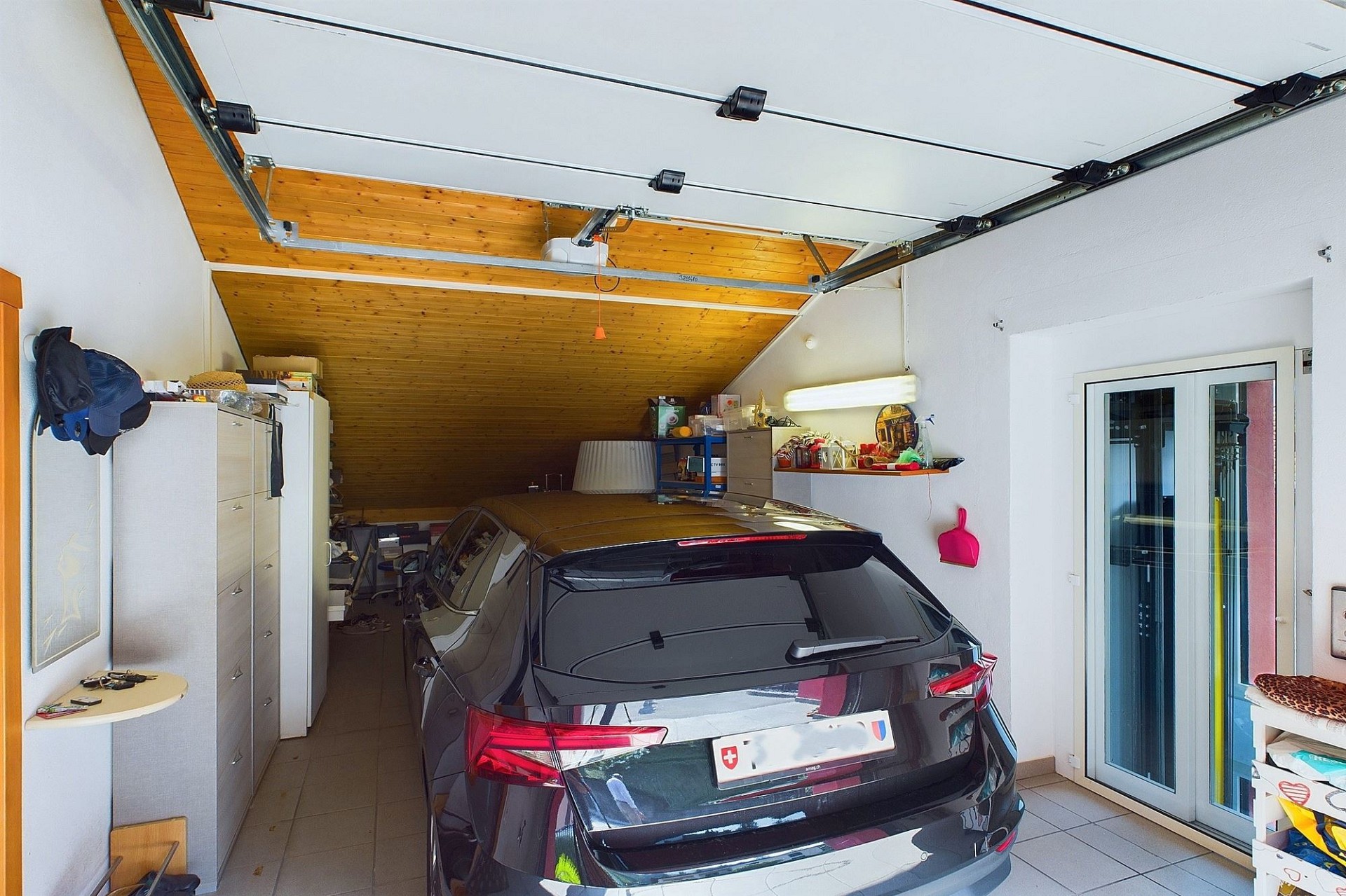 Garage mit geparktem Auto und Dachschräge