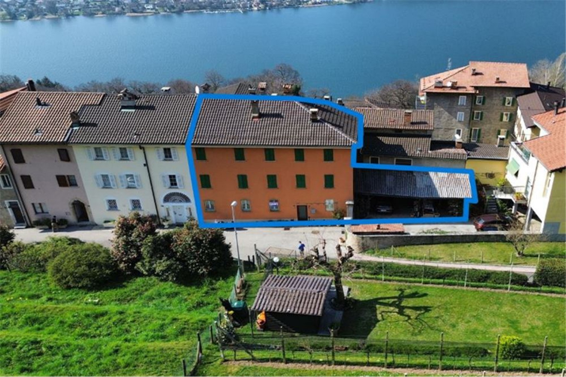 Luftaufnahme eines markierten Mehrfamilienhauses am See