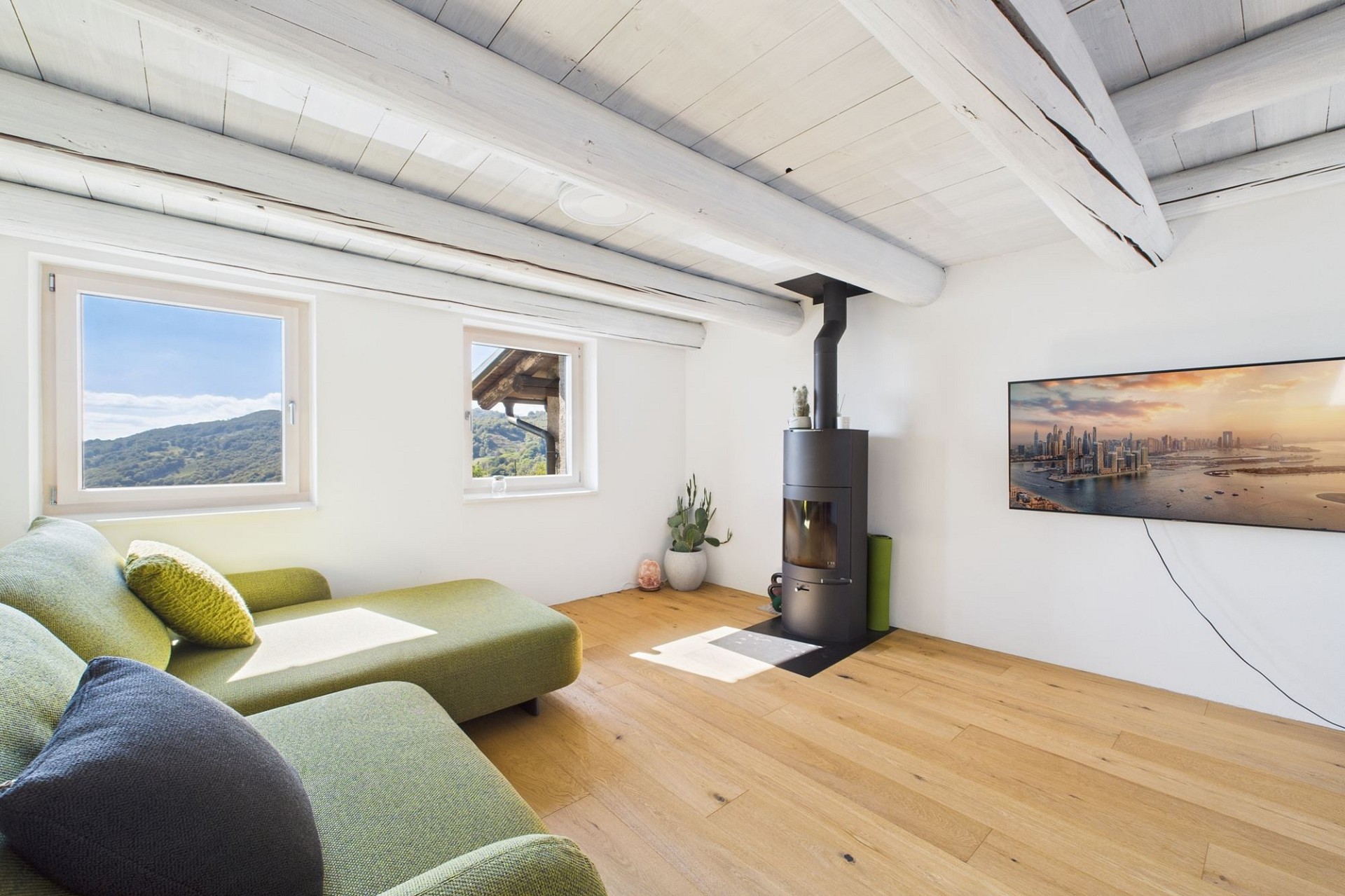 Helles Wohnzimmer mit Kamin und Bergblick