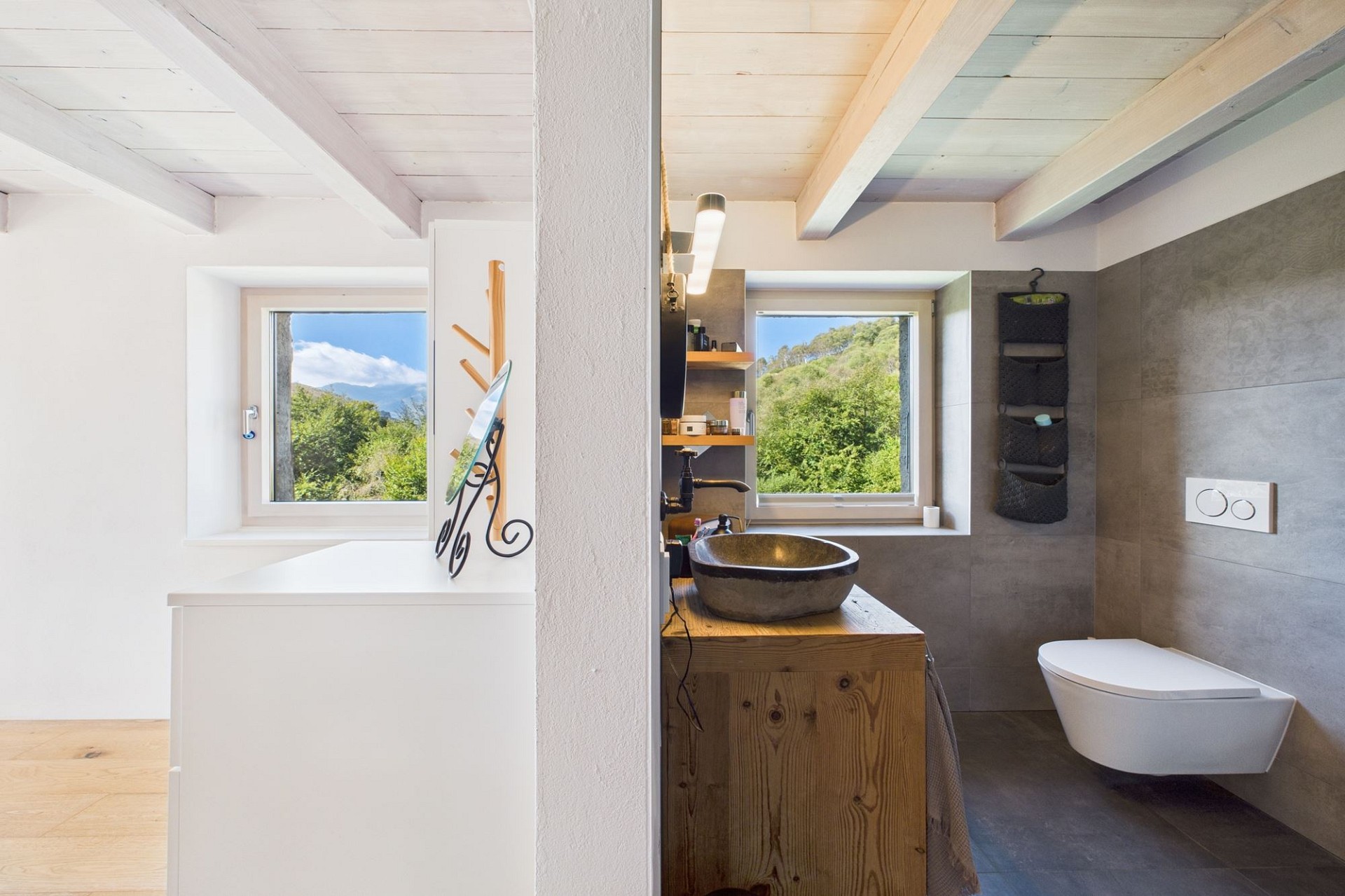 Modernes Badezimmer mit Dachschräge und Blick ins Grüne