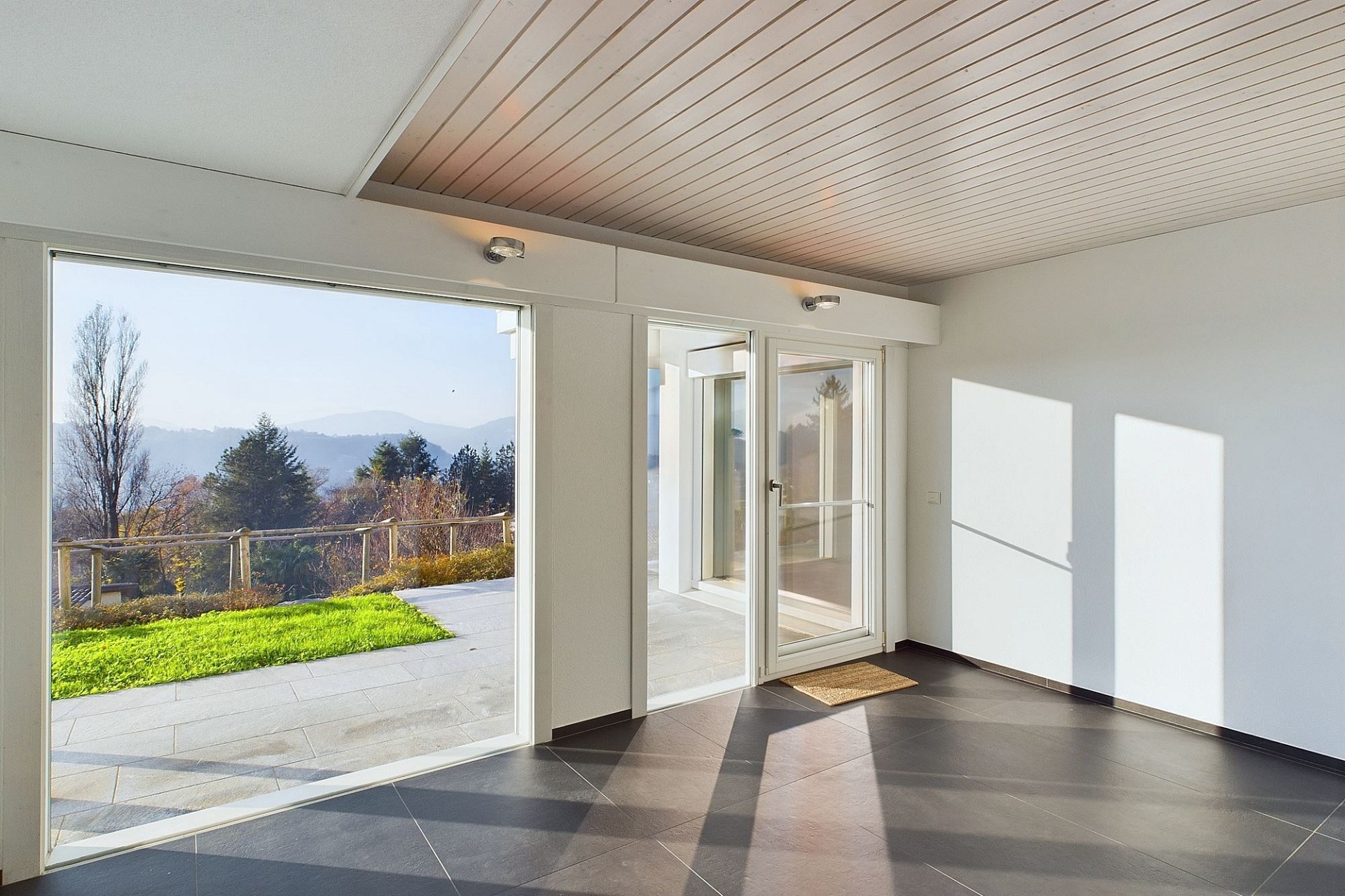 Heller Raum mit großer Glasfront und Bergblick
