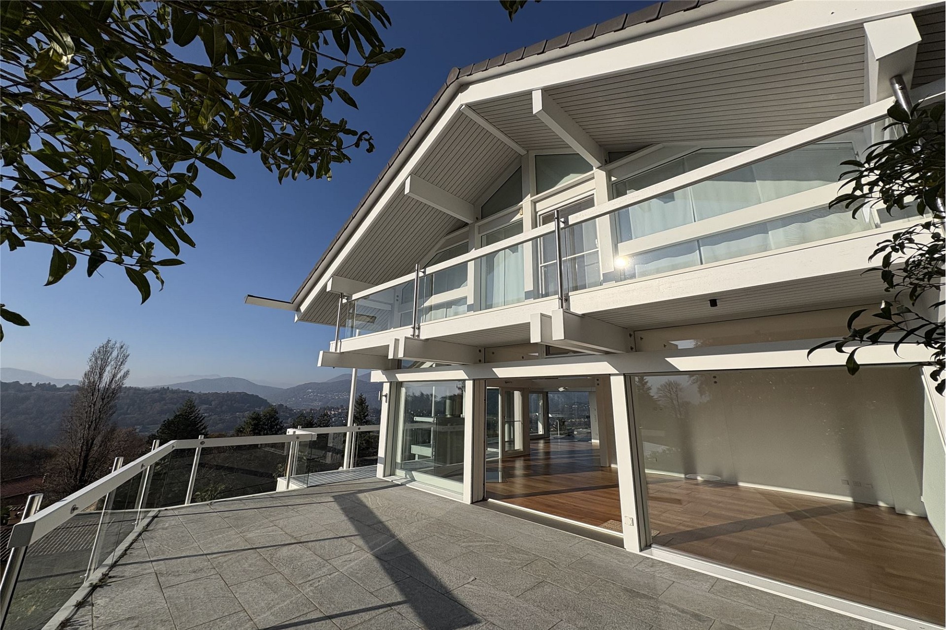 Moderne Hausfassade mit großem Balkon und Talblick