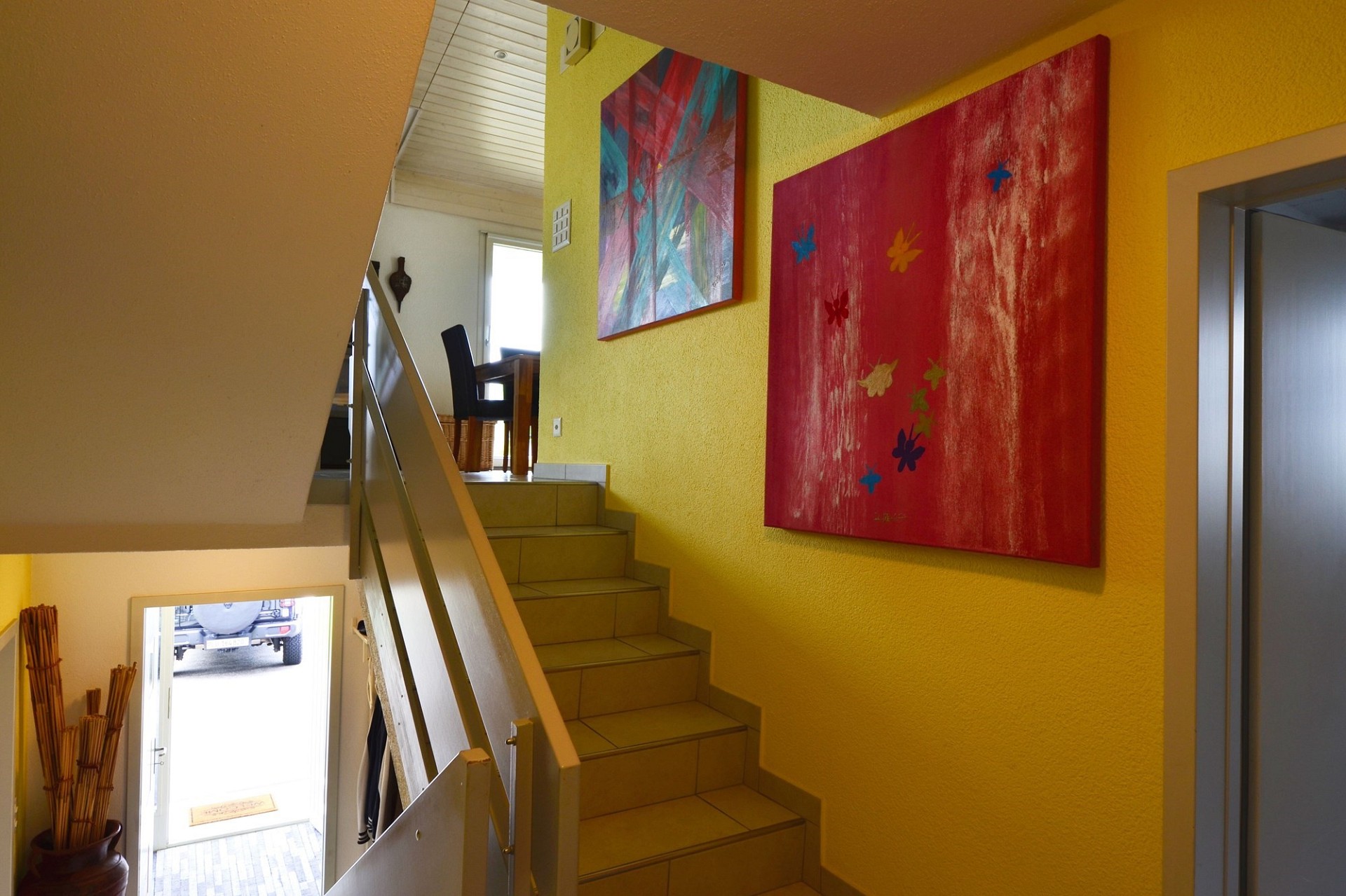 Treppenhaus mit farbigen Wänden und Kunstwerken