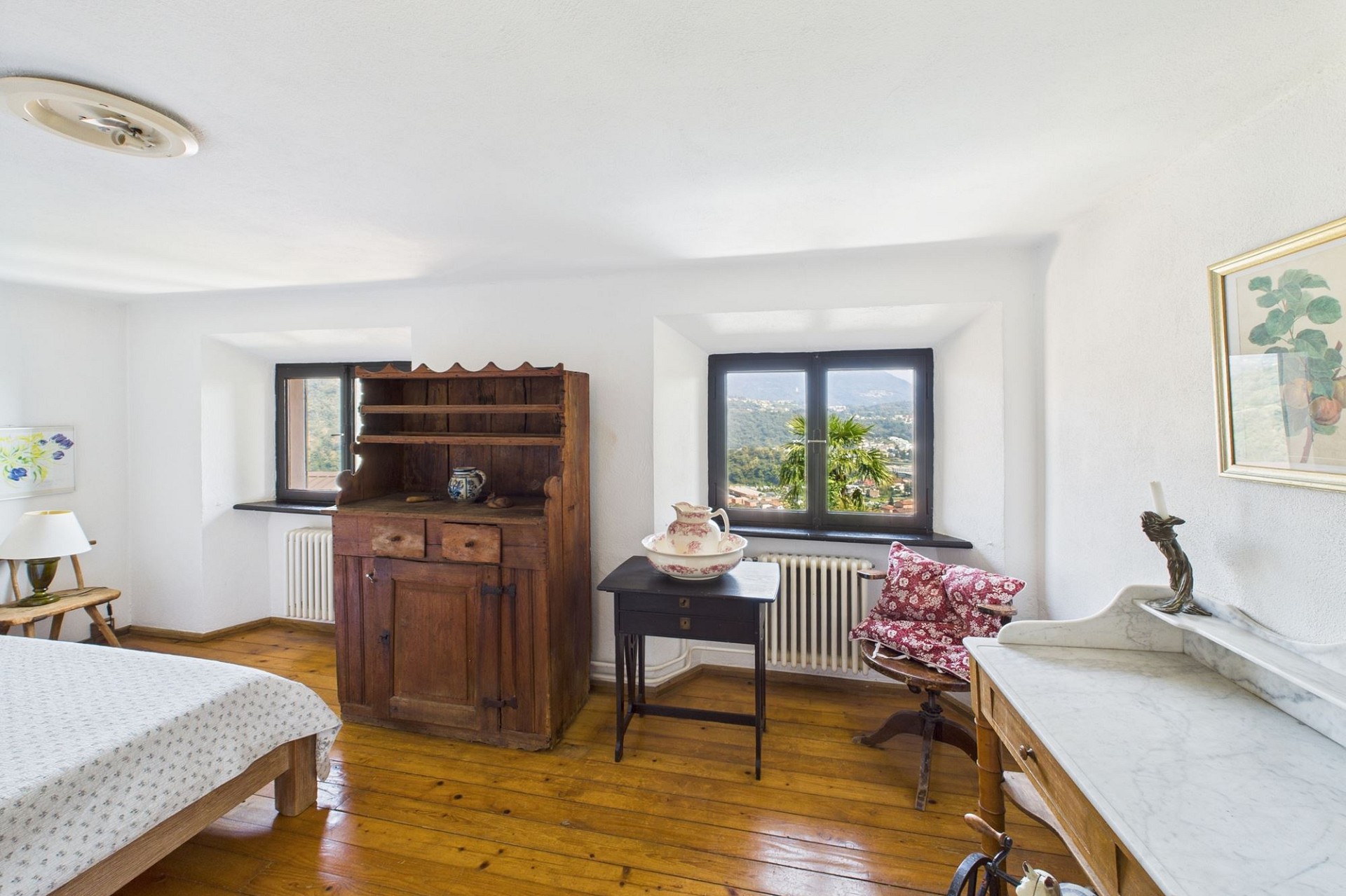 Helles Schlafzimmer mit Holzfußboden und Bergblick