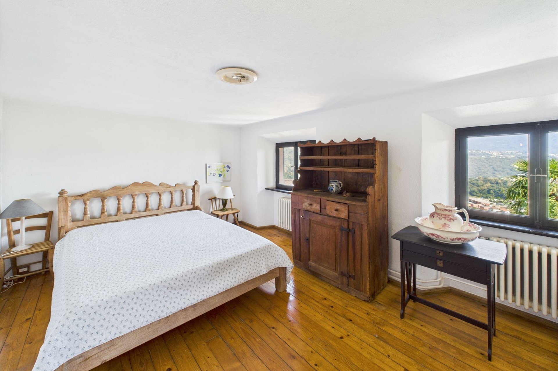 Helles Schlafzimmer mit Holzmöbeln und Bergblick