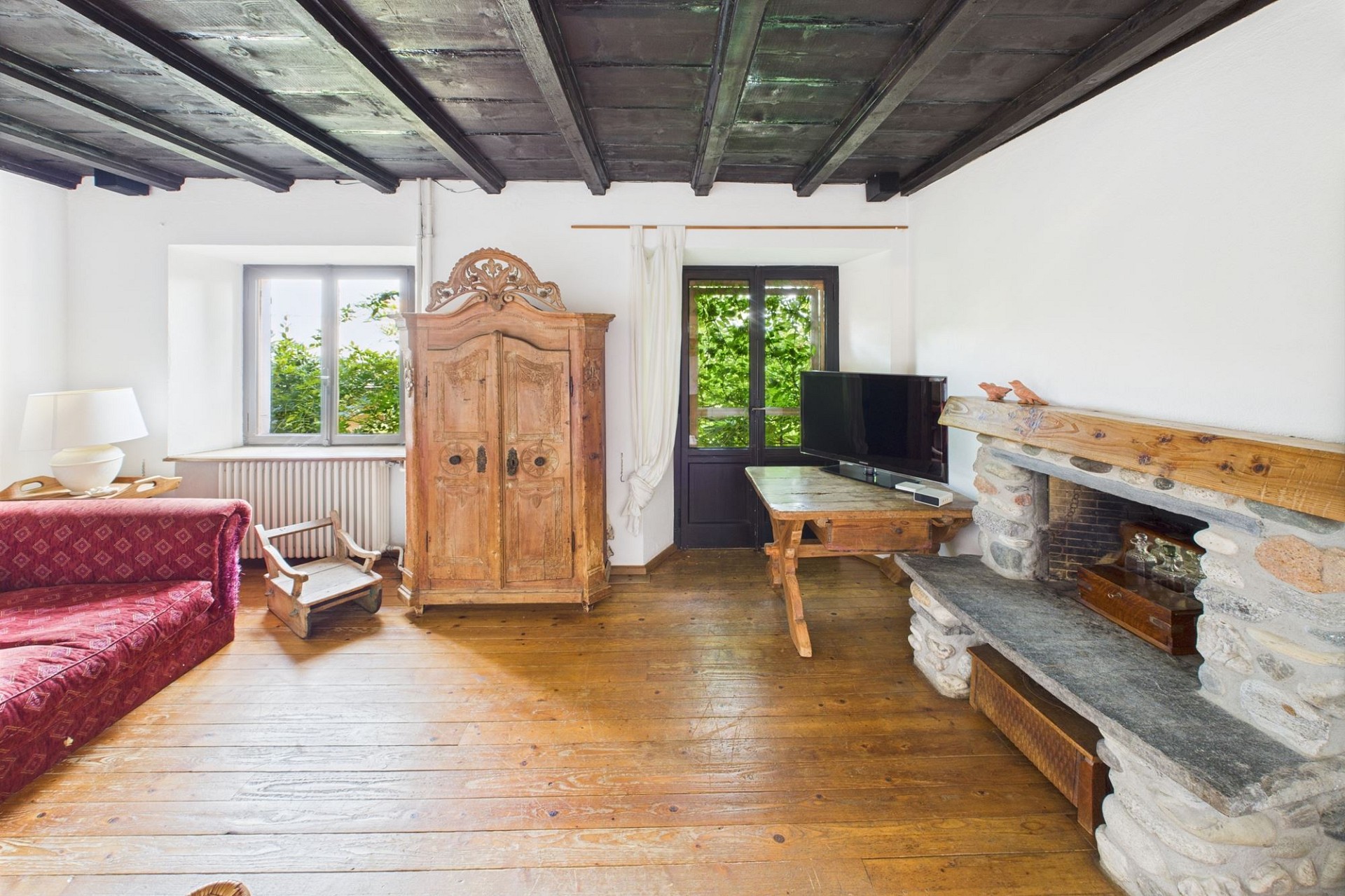Rustikales Wohnzimmer mit Kamin und antikem Mobiliar