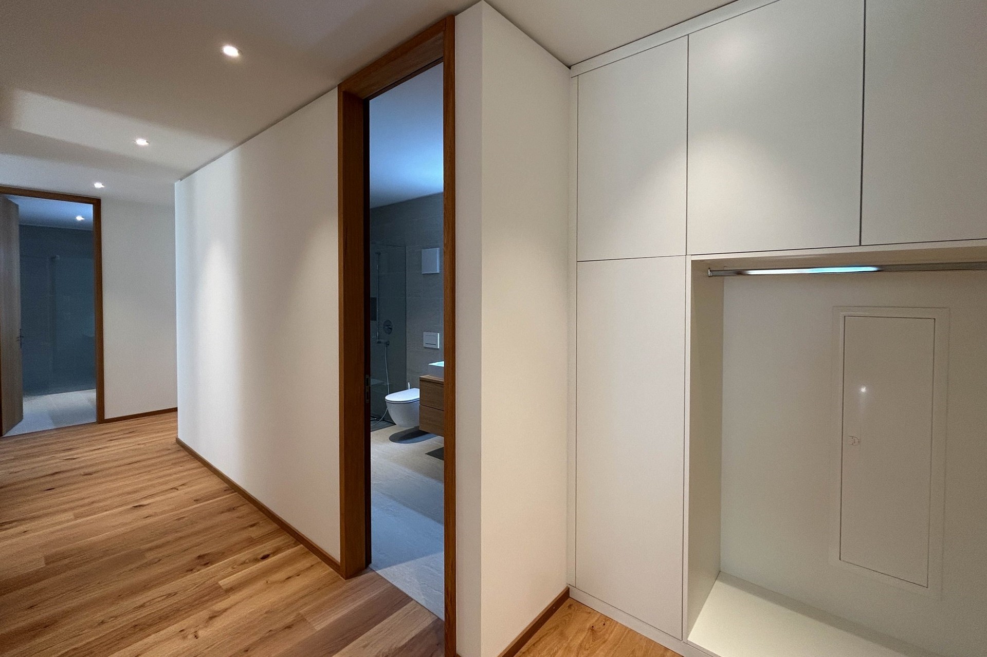 Moderner Flur mit Einbauschrank und Blick ins Bad