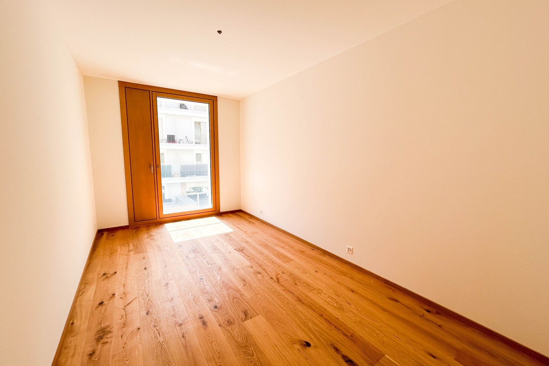 Helles, leeres Zimmer mit Balkon- oder Fenstertür