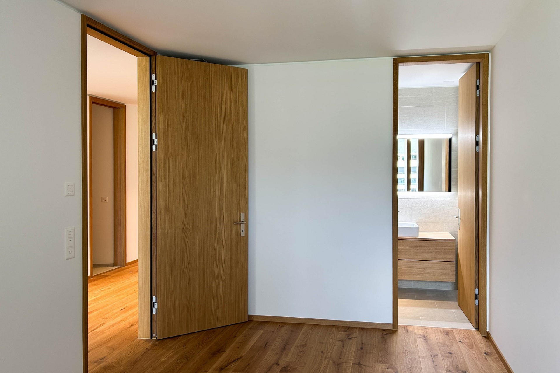 Helles Schlafzimmer mit Blick in Bad und Flur