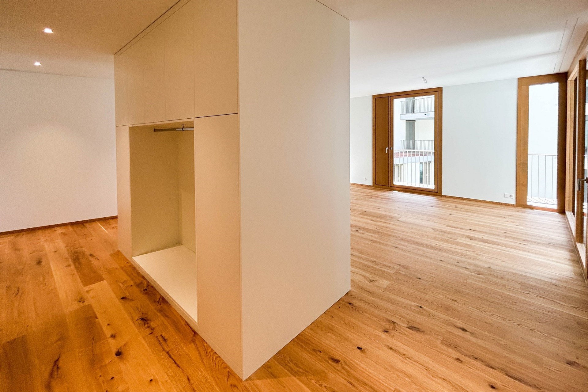 Heller Wohnraum mit Einbauschrank und Balkonzugang