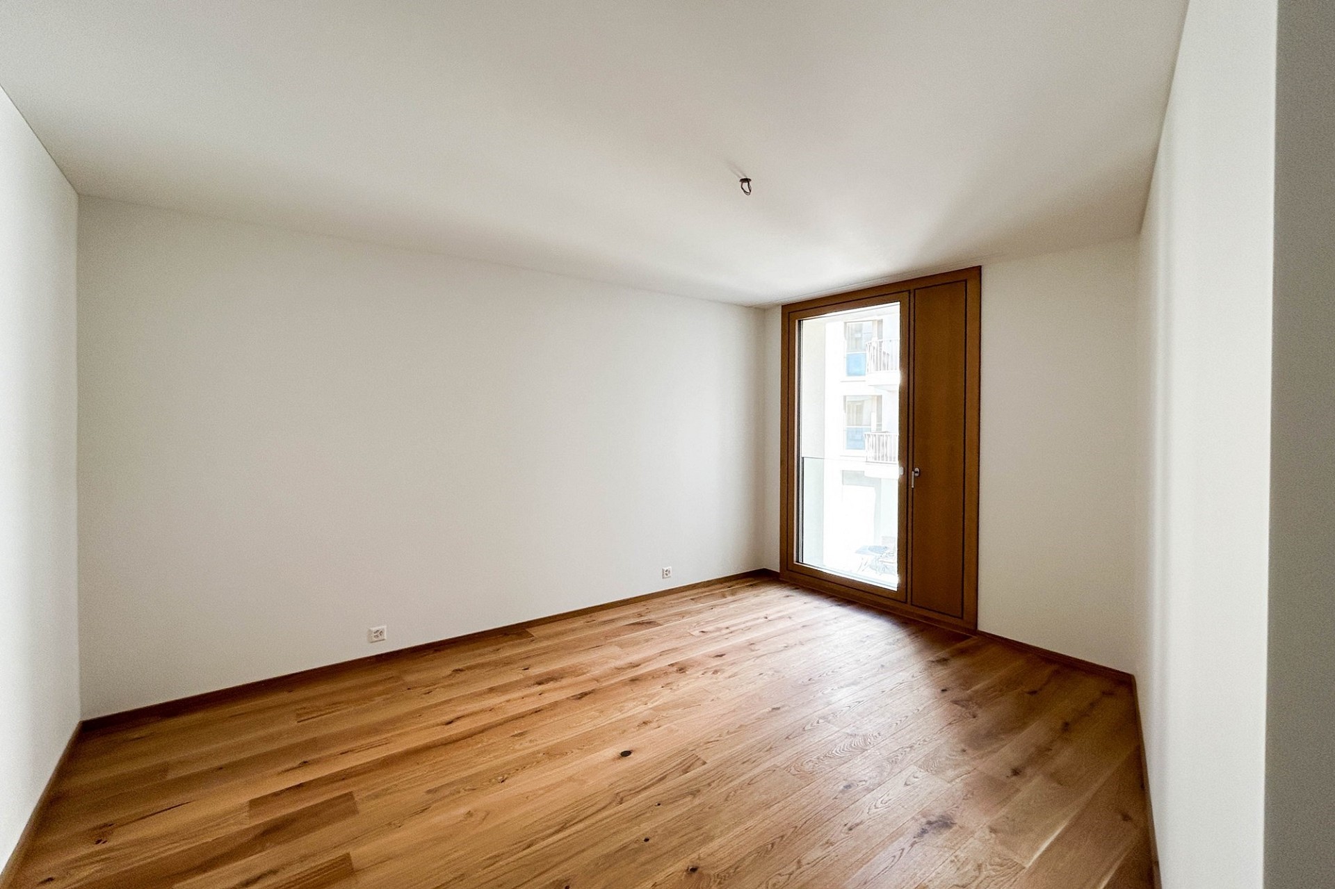 Leerer Raum mit Holzfußboden und großem Fenster