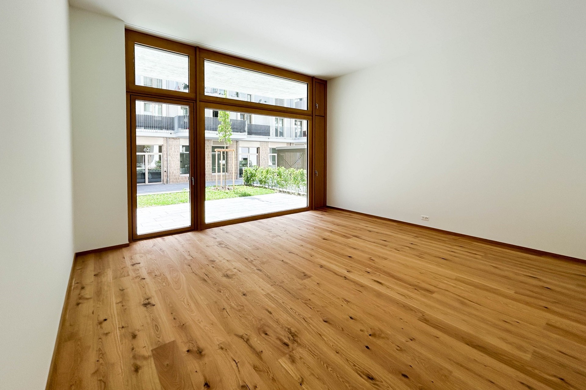 Heller leerer Wohnraum mit großer Fensterfront