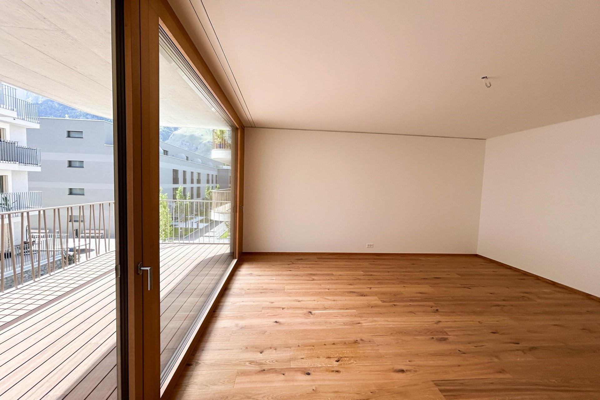 Leerer Wohnraum mit Balkonzugang